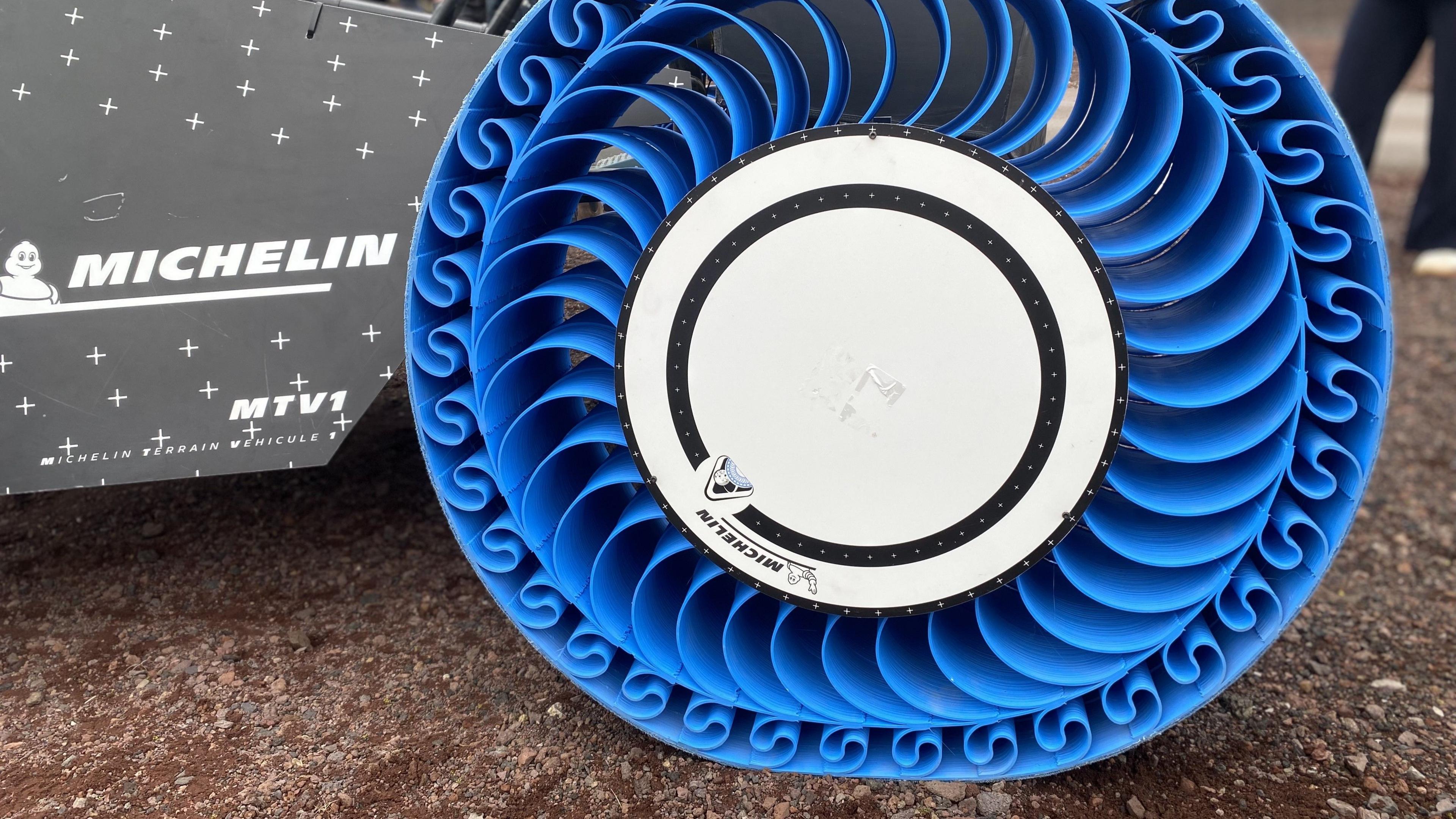 Michelin's bright blue plastic wheel - curved spokes support a wide solid rim.