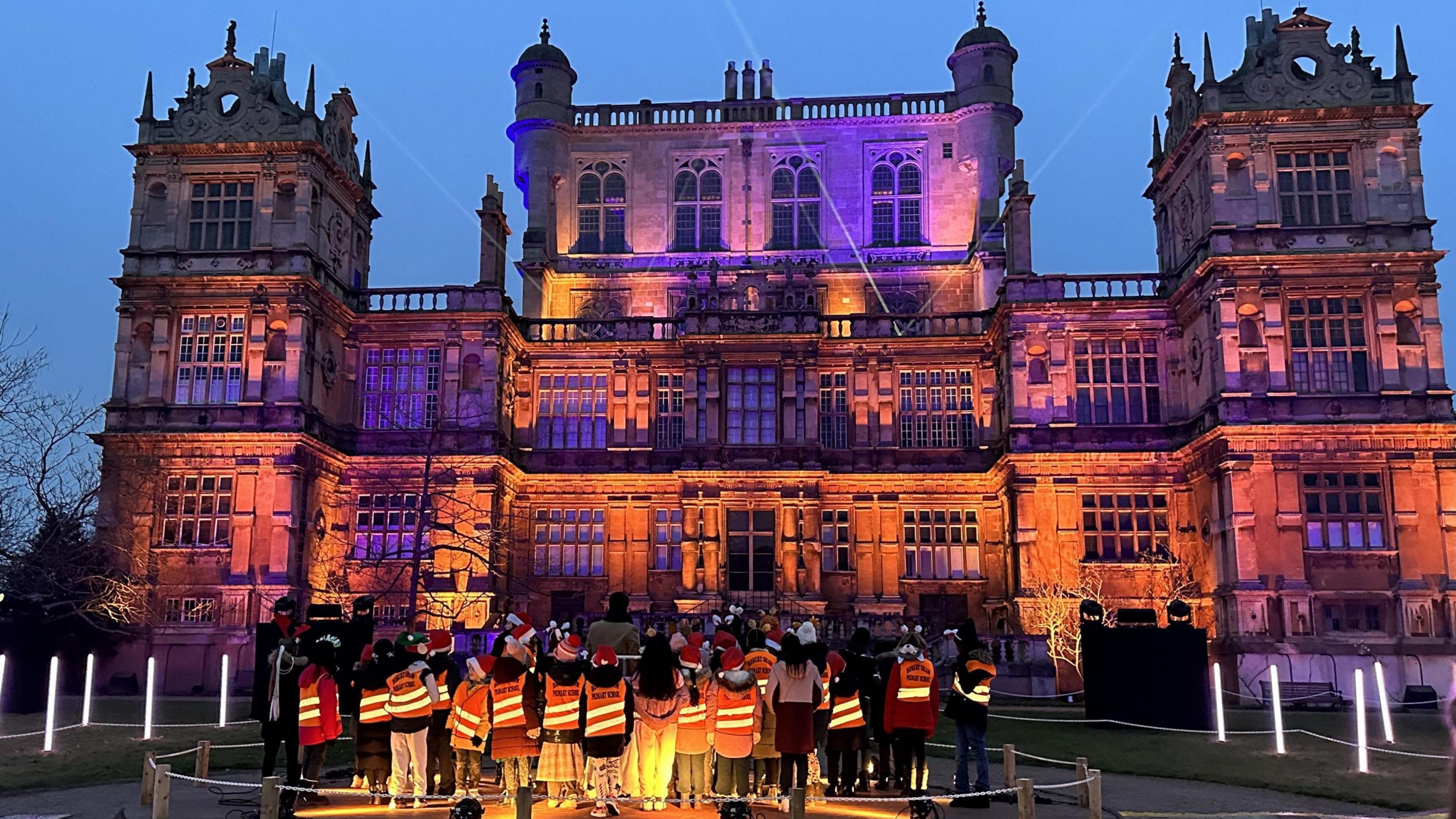 Wollaton Hall is pictured with a group of workers in front of lights.