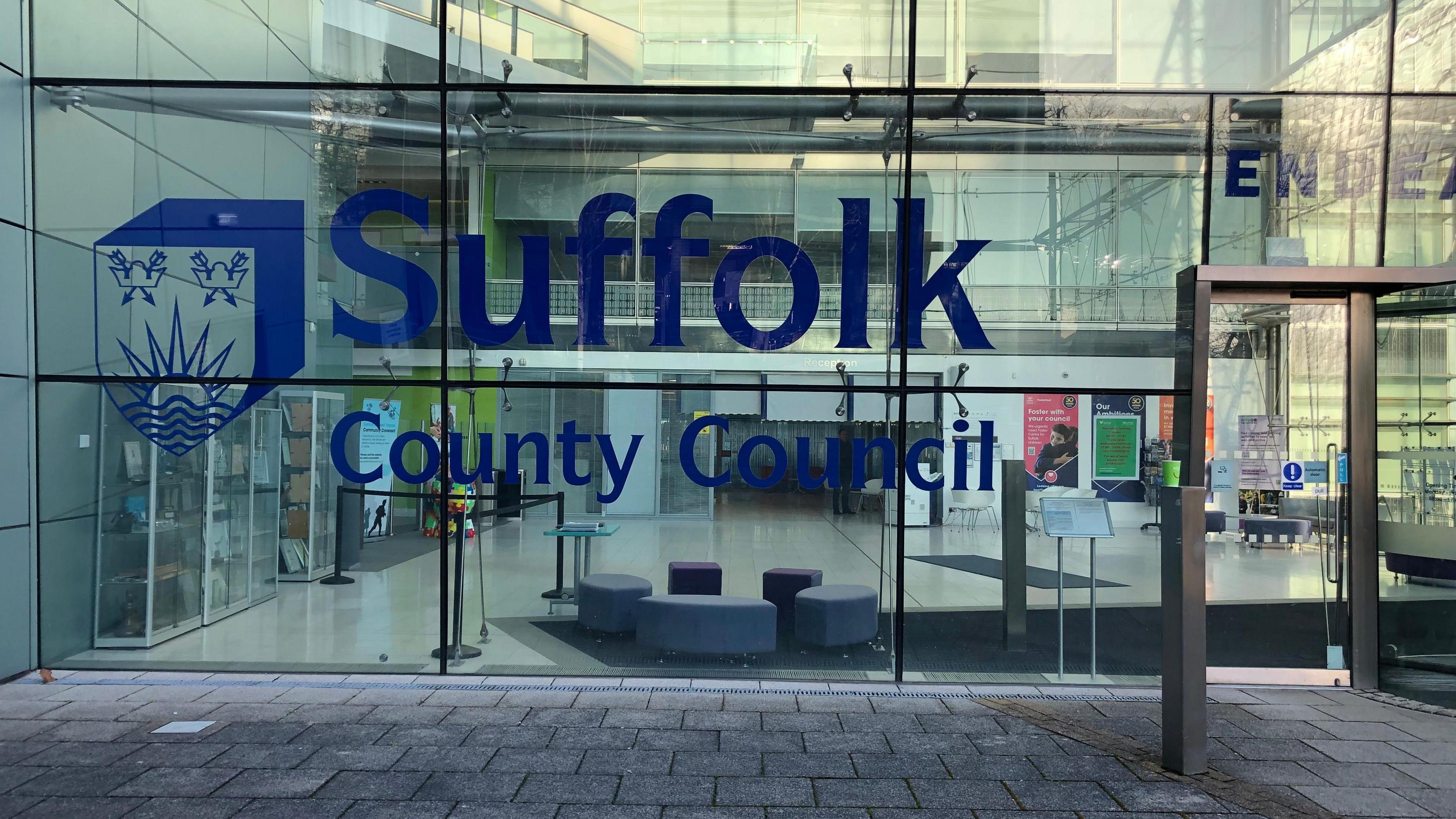 The front of Suffolk County council's offices in Ipswich with "Suffolk County Council" written on the glass