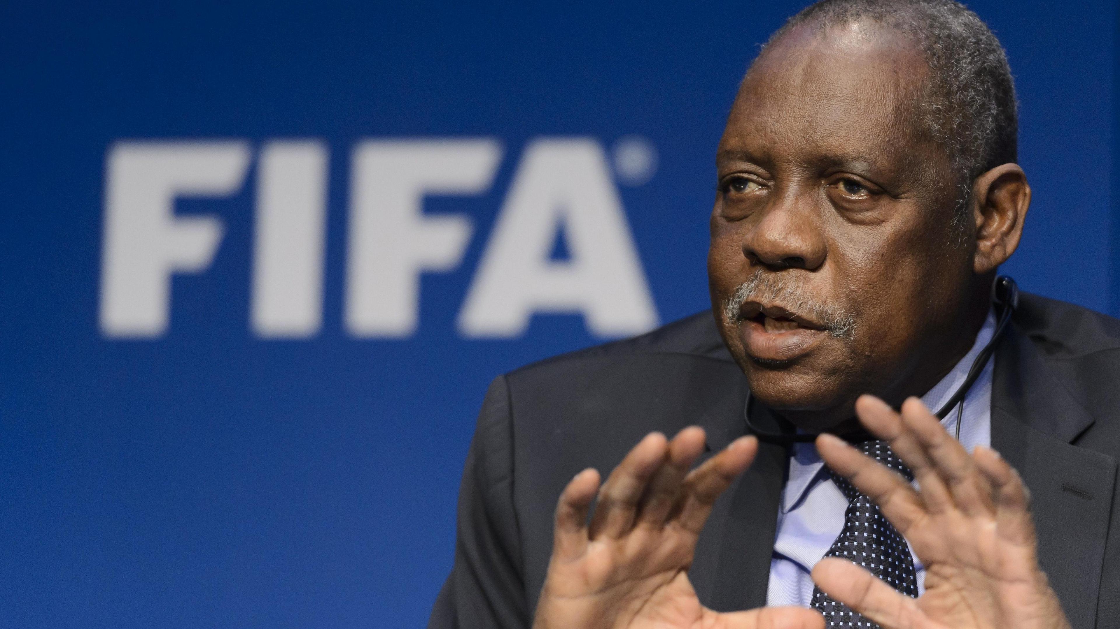 Issa Hayatou gestures in front of a Fifa sign