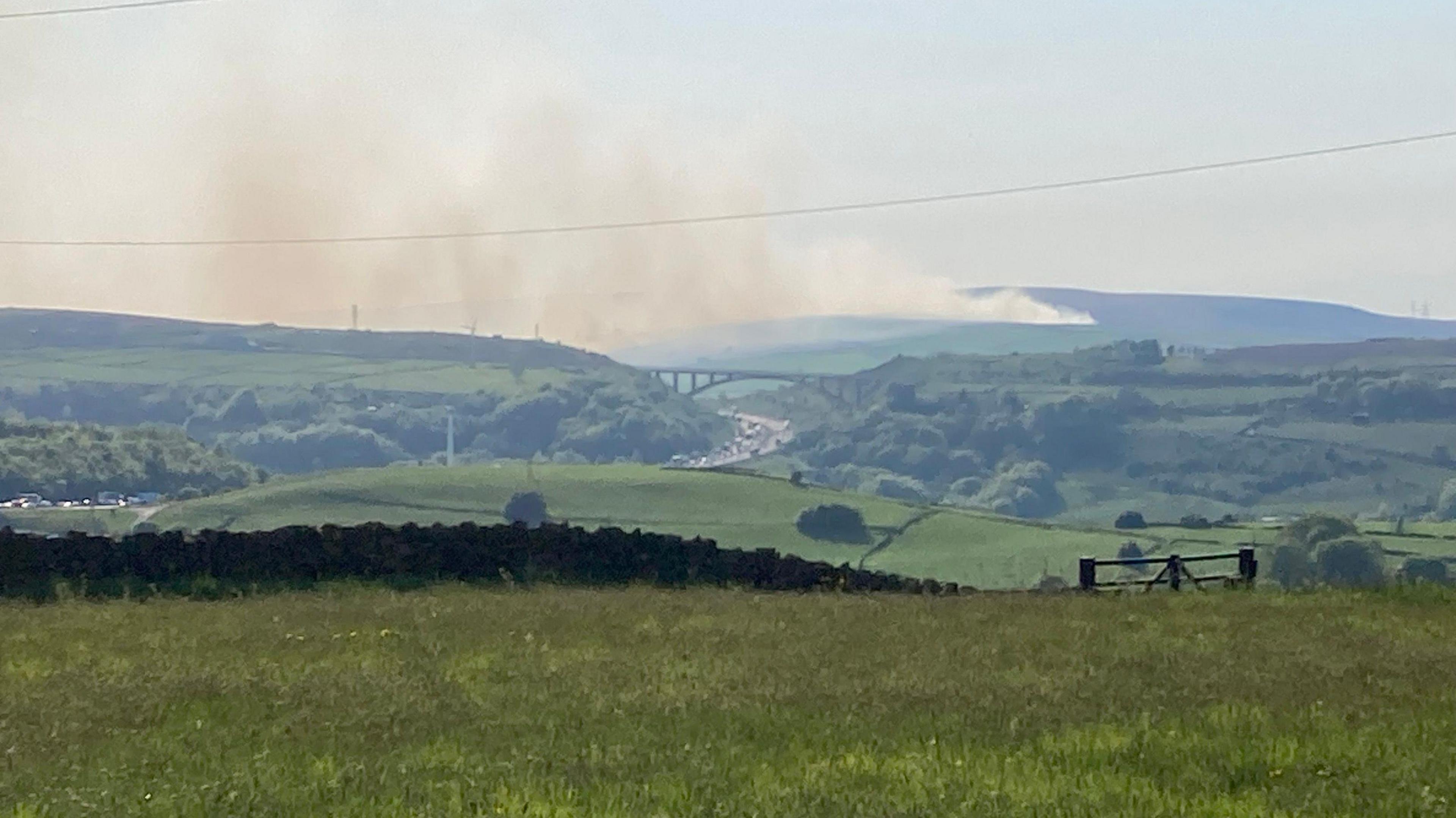 Smoke from the fire visible in the distance from a photo taken several miles away.