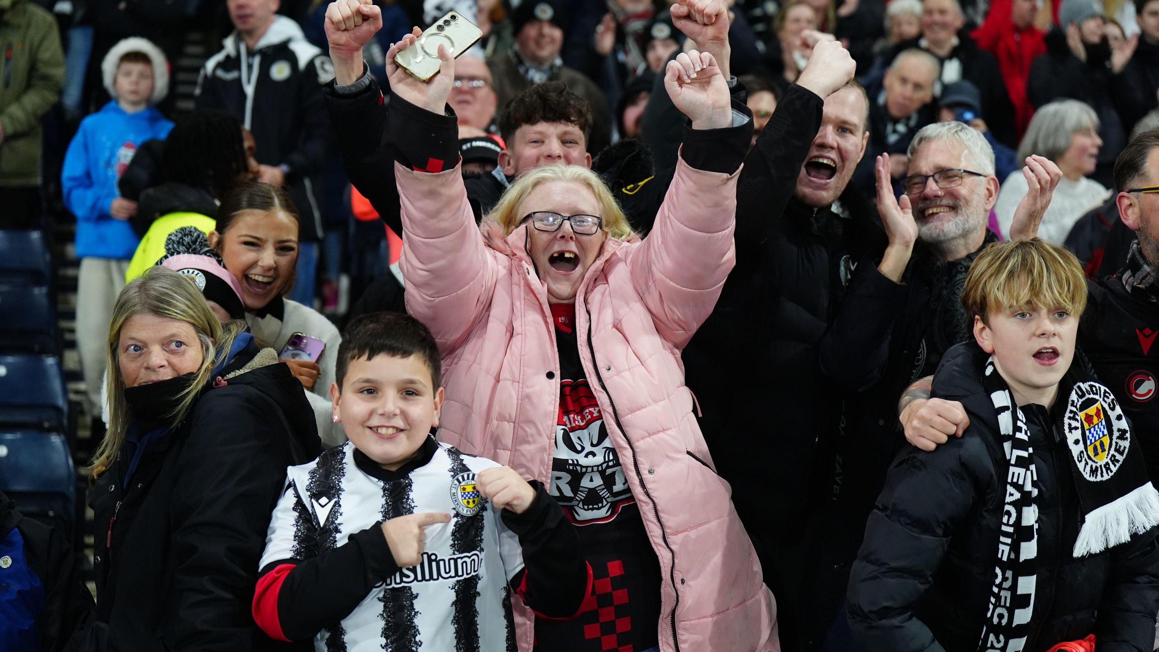 A group of St Mirren football fans cheer and celebrate in the stands