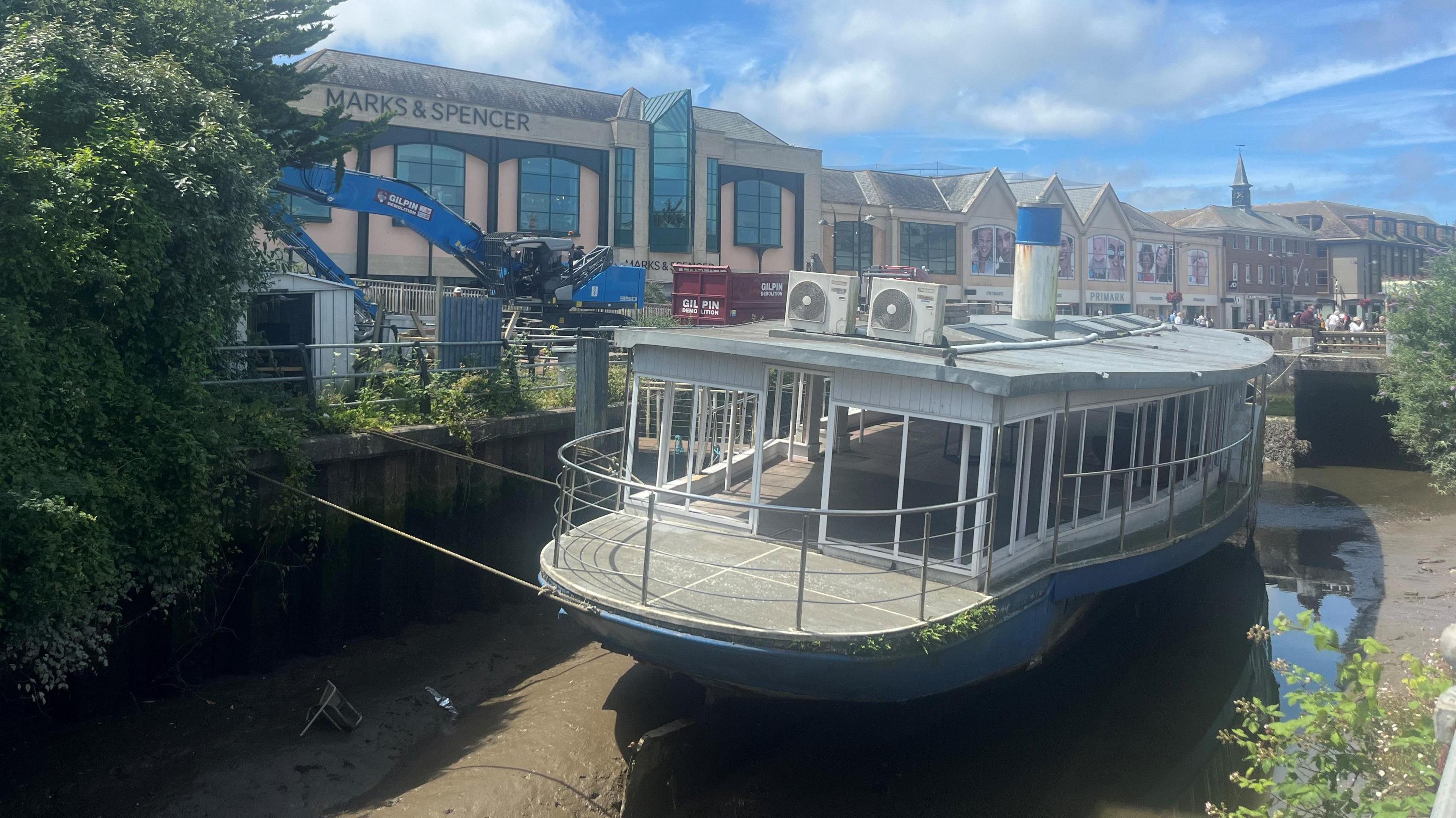 Old paddle steamer with big blue digger behind