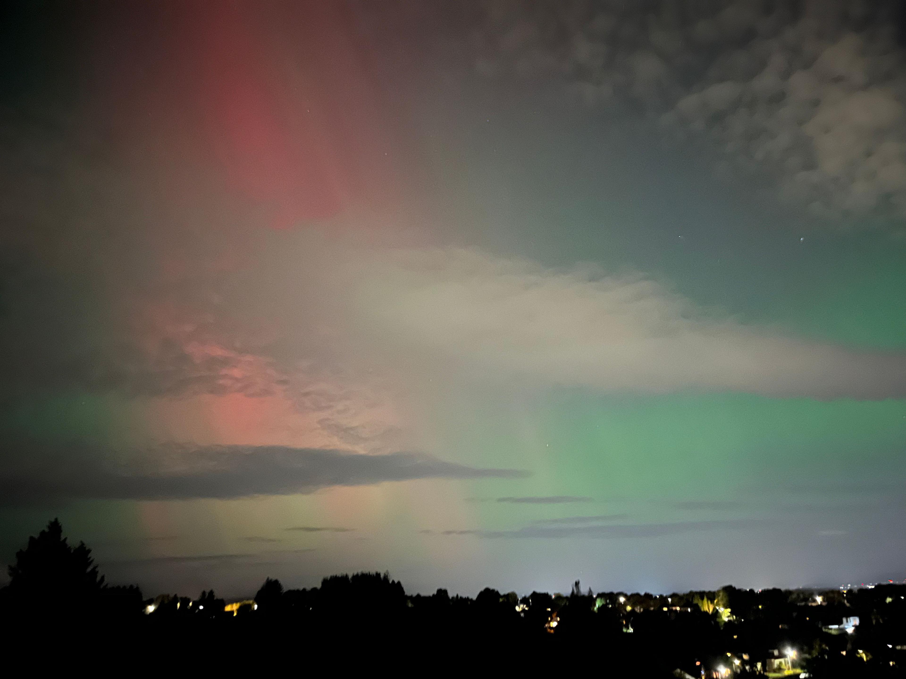 Red and green rays behind clouds in Thornliebank, Scotland