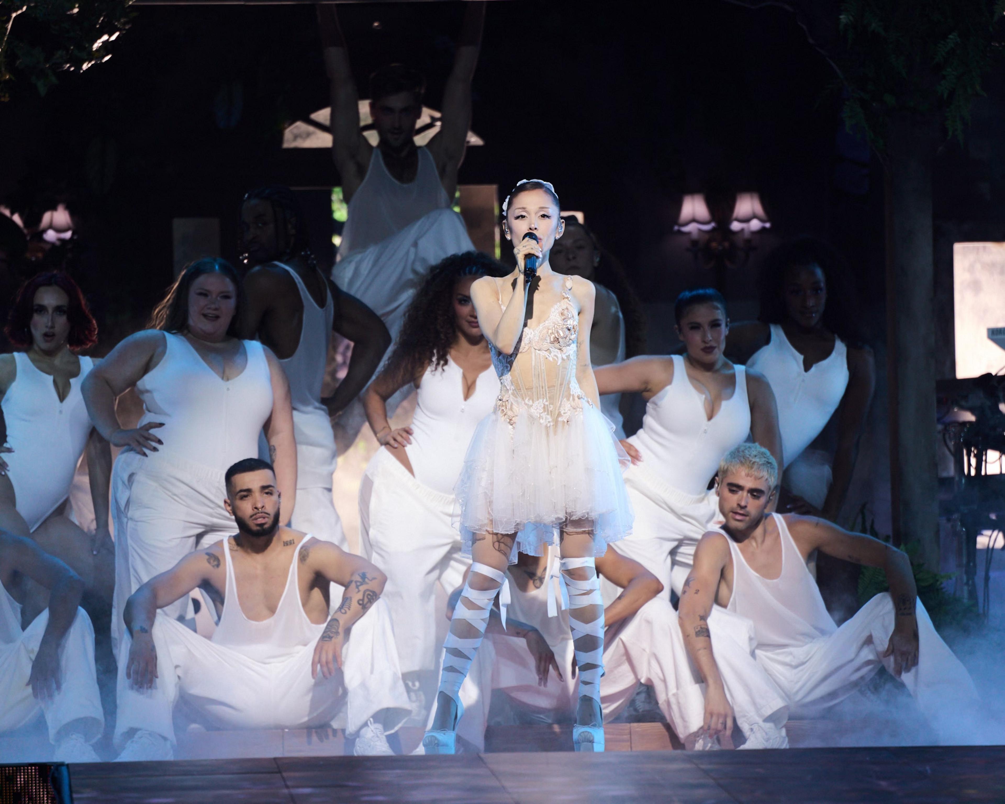 Ariana Grande  at the Oakland Arena on June 6 in California. She is dressed in a white lace dress, surrounded by dancers in plain white costumes