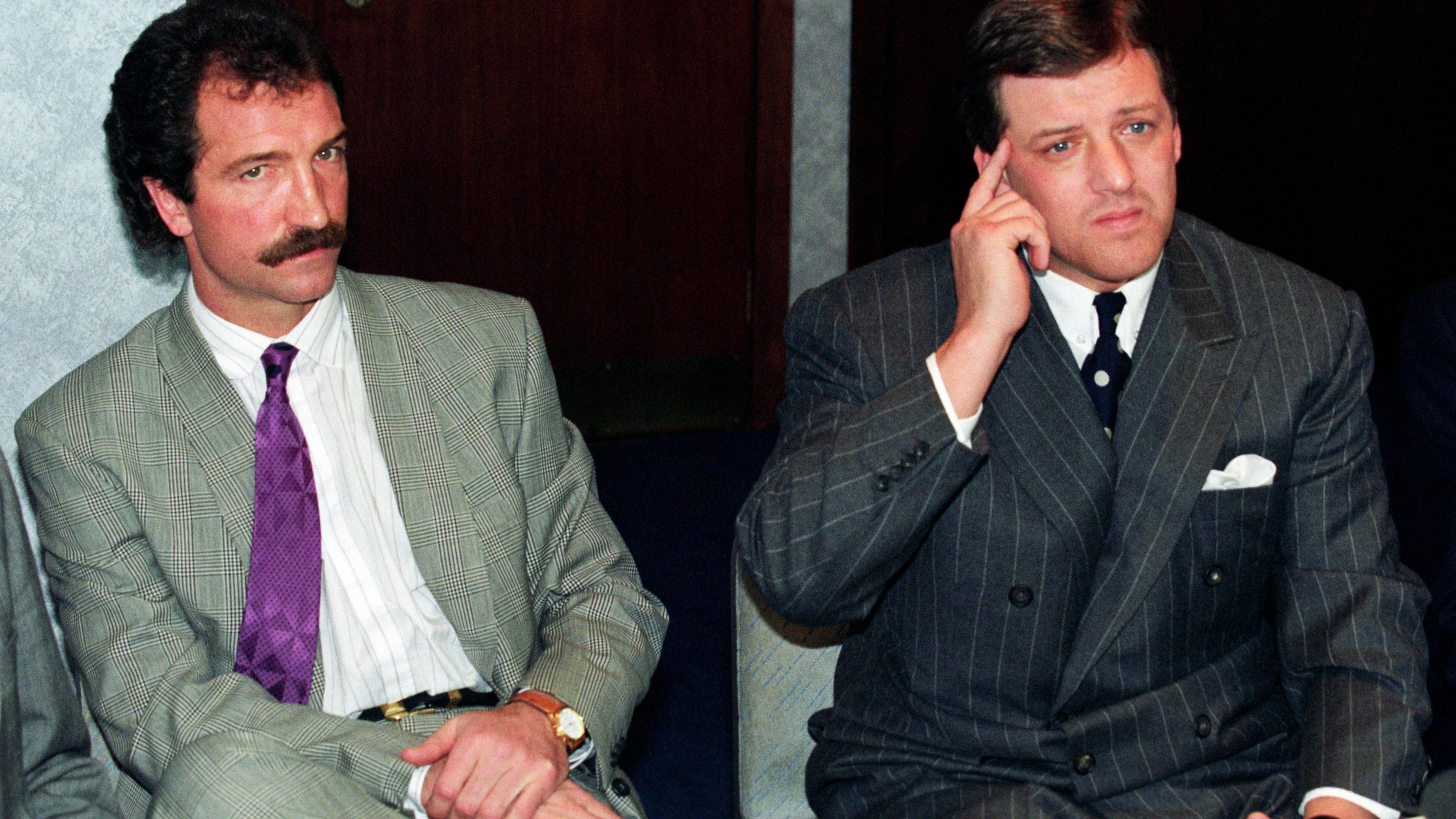 Graeme Souness and David Murray at a press conference. Moustachioed Souness wears a patterned green suit, a purple tie and white shirt. Murray wears a pinstriped black suit, a white shirt and what appears to be a white and black polka dot tie, though his broad lapel covers most of it.