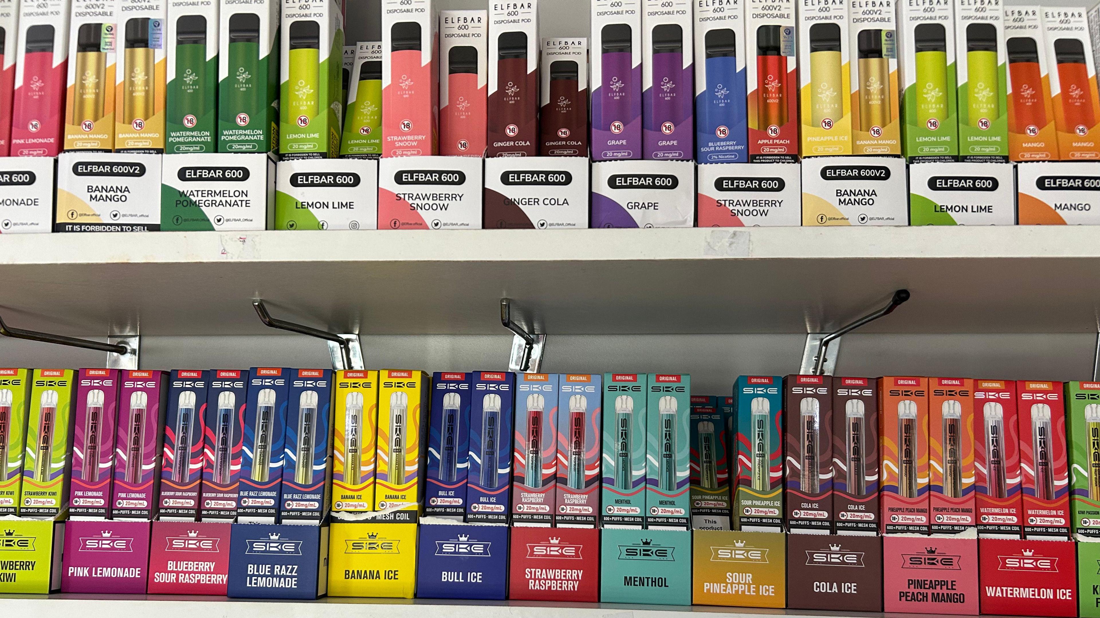 A number of disposable vapes on a shop shelf