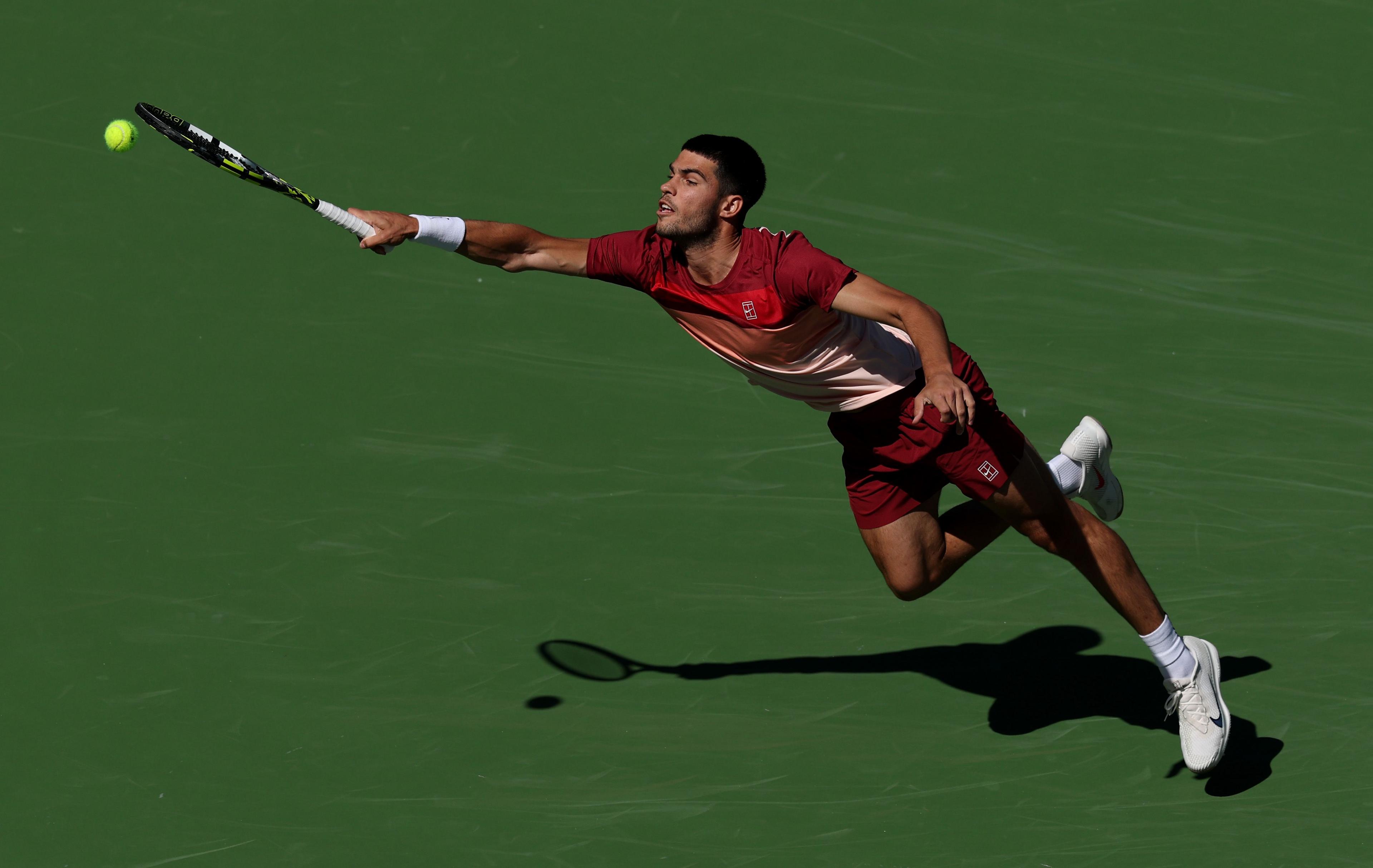 Spains Carlos Alcaraz stretches to play a forehand against Quentin Halys of France in their second round match during the BNP Paribas Open at Indian Wells Tennis Garden in California