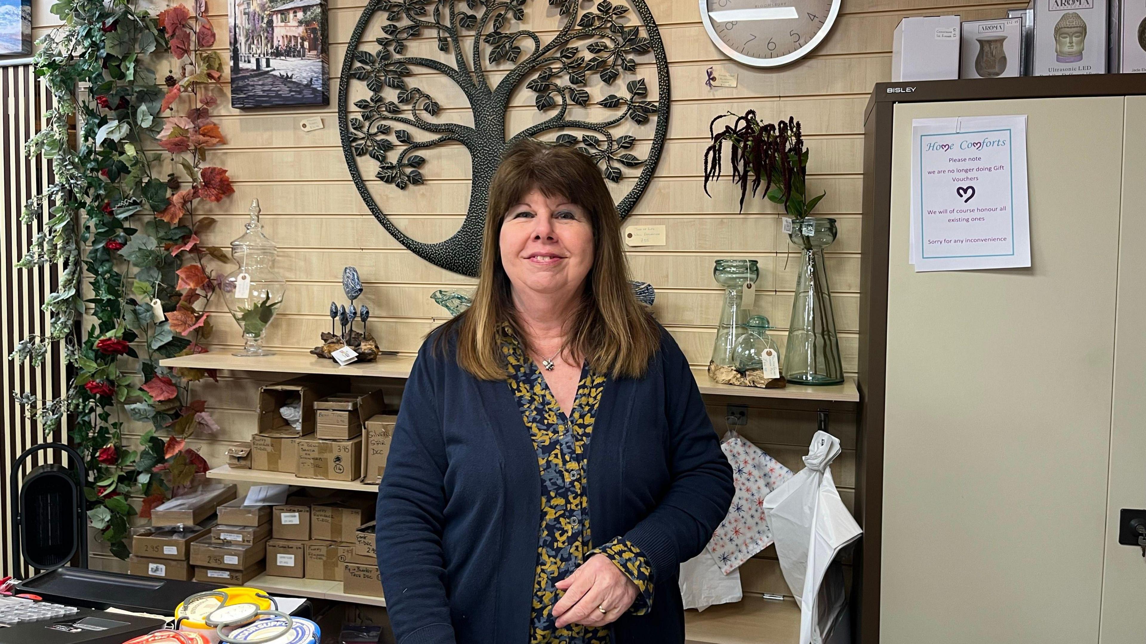 Image of the owner of Home Comforts, Kathy Sanders, behind the tills of her shop