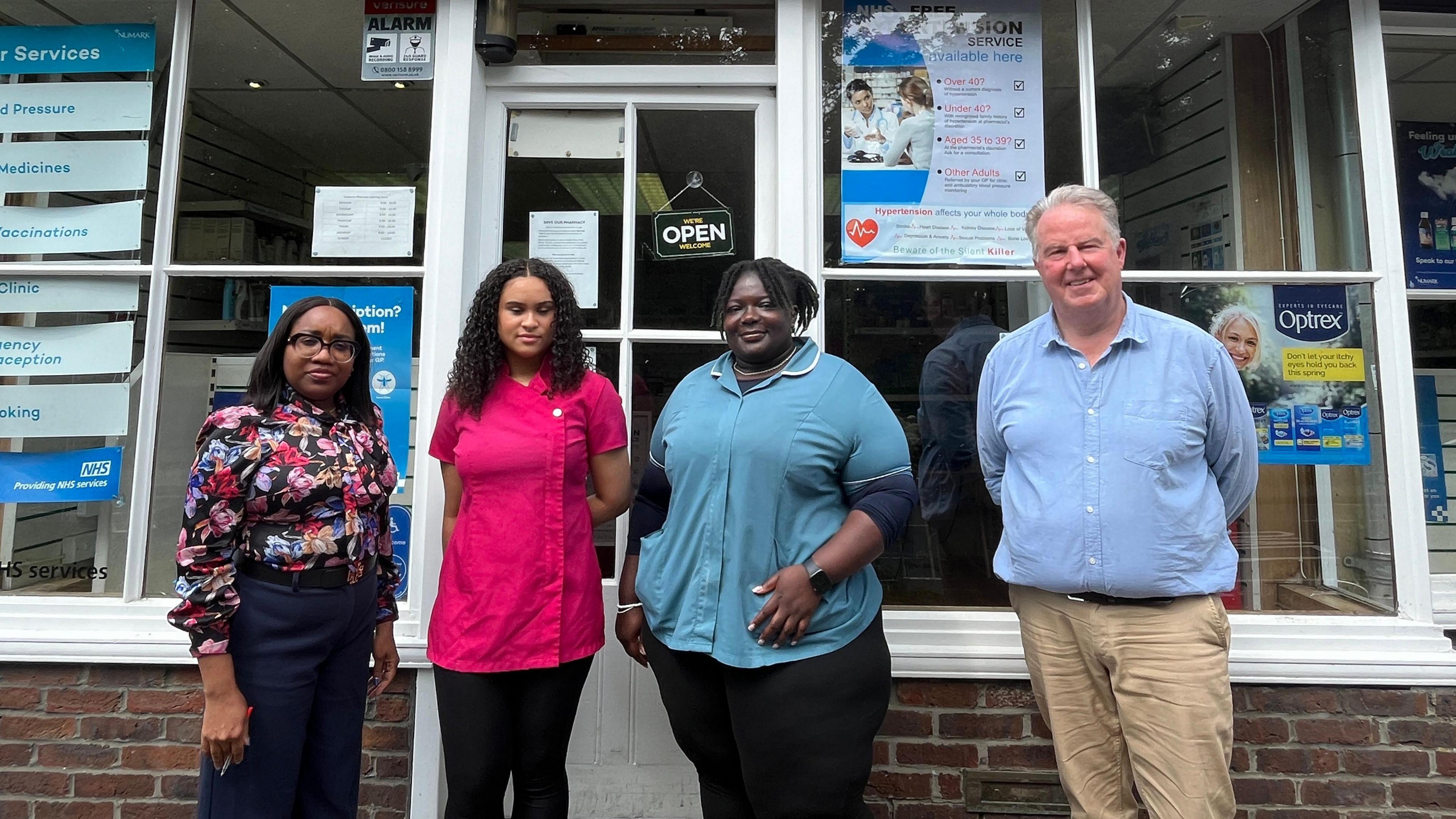 Ifesi Anyamene, Alban Smith-Brindle from the patient participation group, staff Melton Kent Flynn and Jasmine Westfold stand outside the Godstone Pharmacy