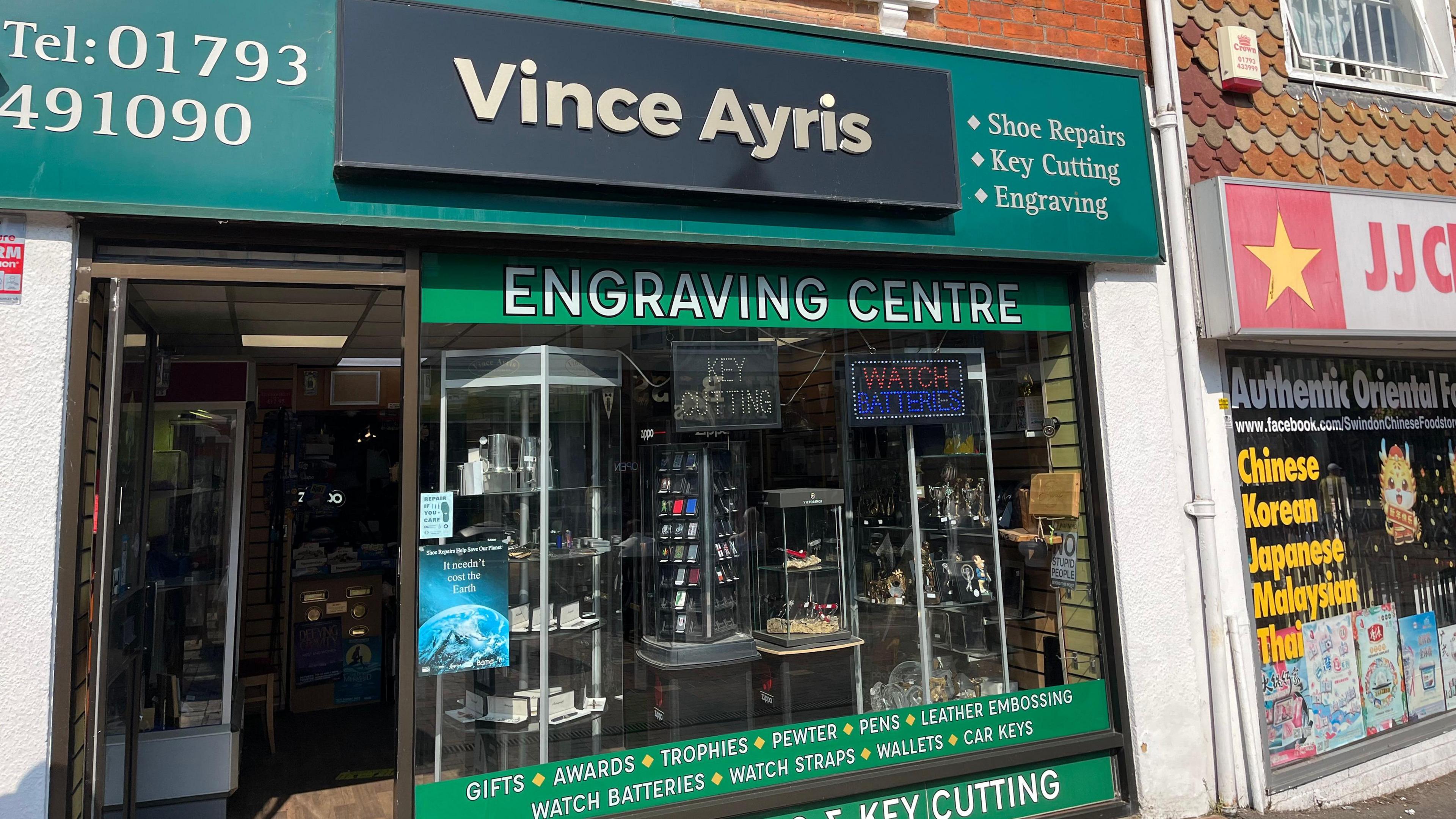 Mr Ayris's shopfront. In the window you can see displays of watches, lighters, and jewellery 