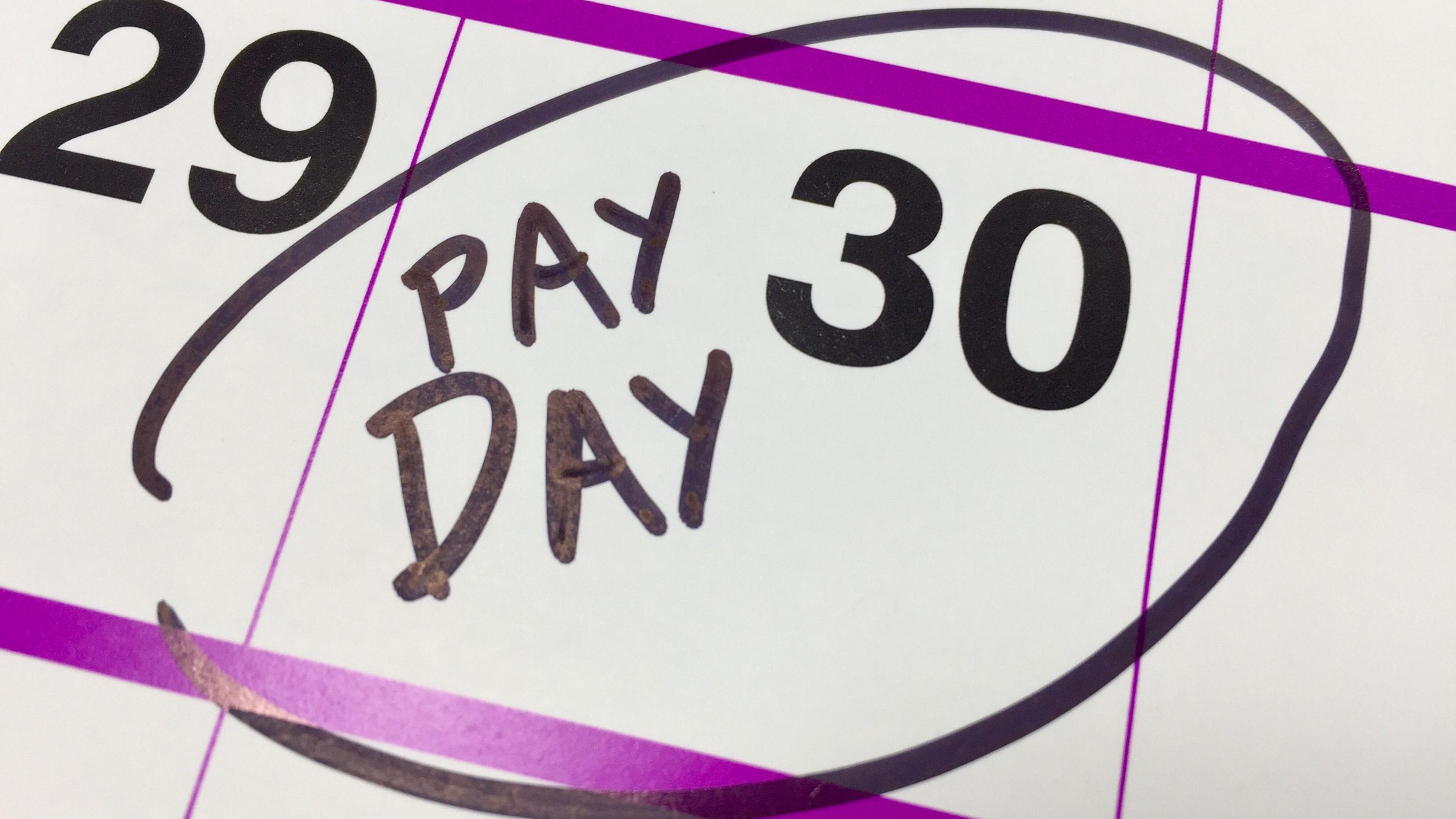 A calendar showing 'pay day' highlighted on the 30th of an unknown month - it is a stock photo