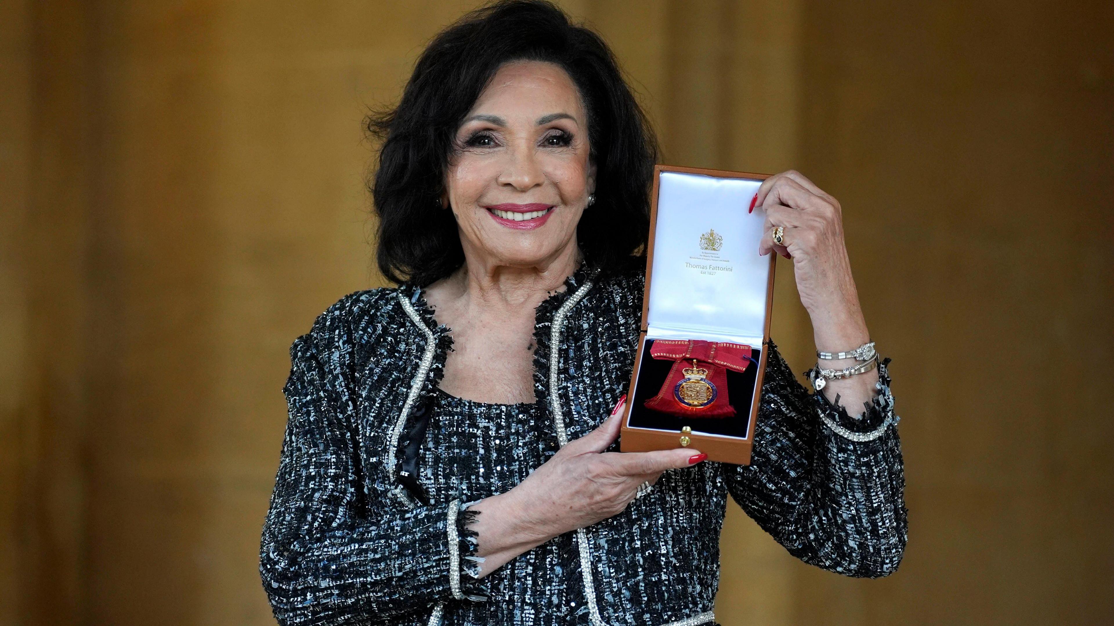 Shirley Bassey poses with her Companion of Honour medal at Windsor Castle