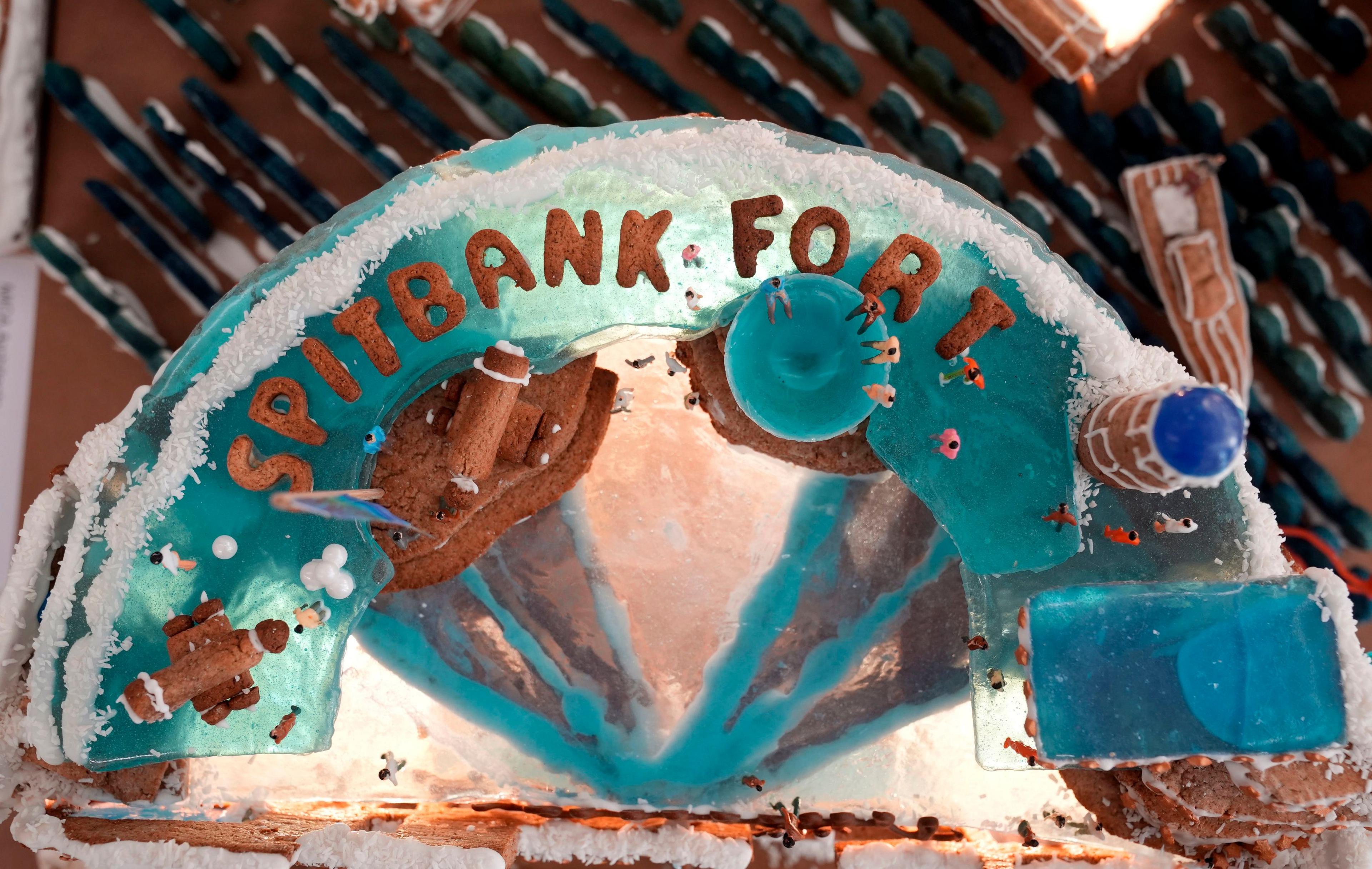 Gingerbread model of Spitbank Fort, with miniature figures on top. It is covered in blue glassine icing. 