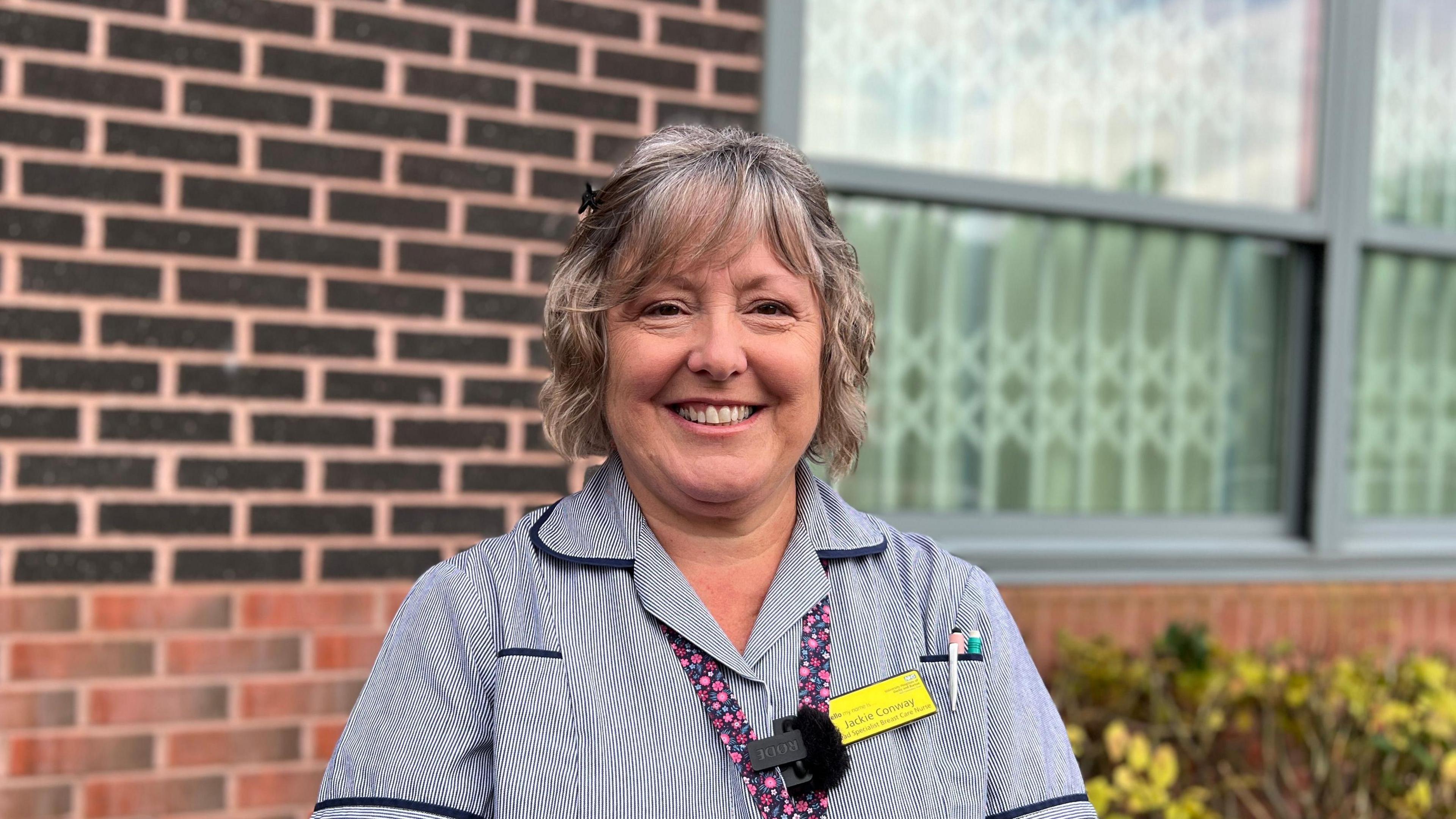 A woman who works for the NHS standing outside St. Oswald's Hospital in Ashbourne, Derbyshire.