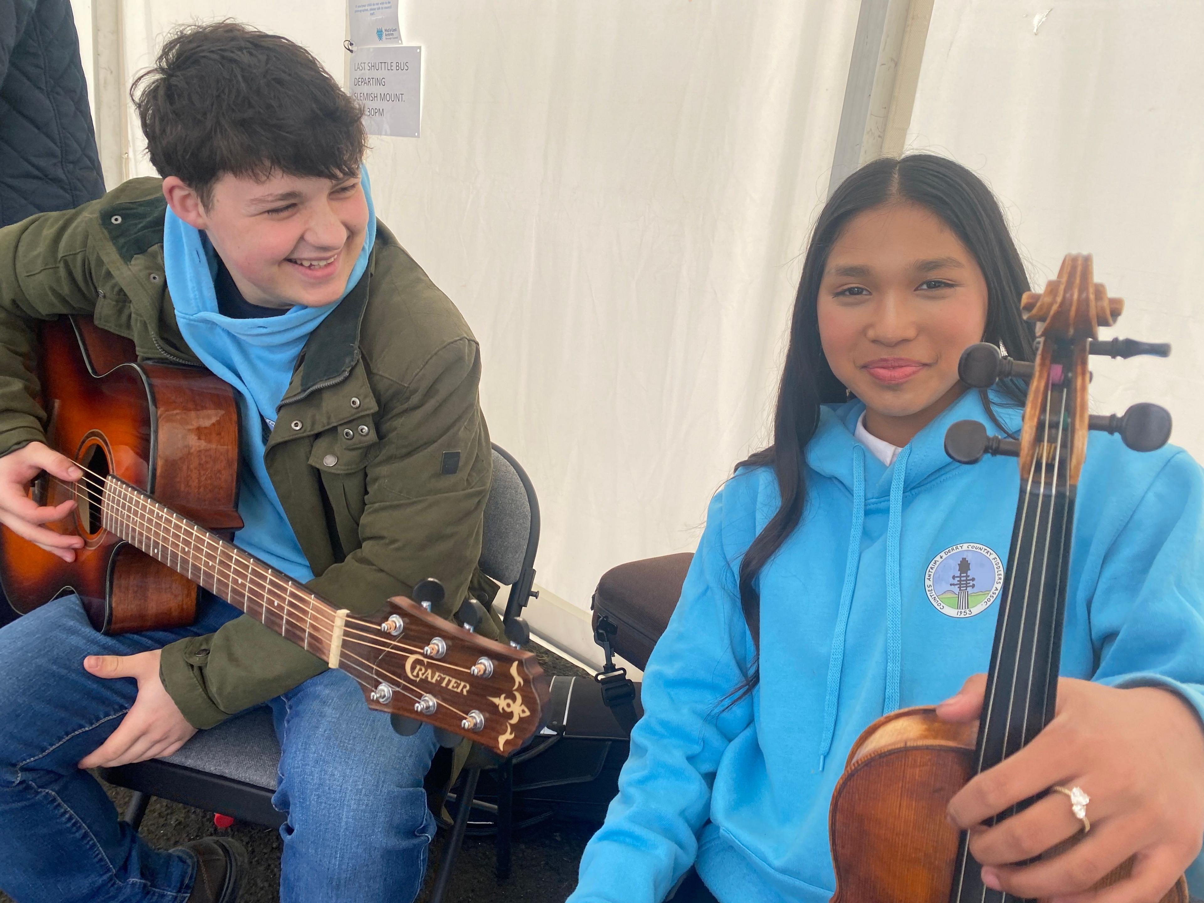 Ana Gallagher with a violin and Edward McKendry with a guitar