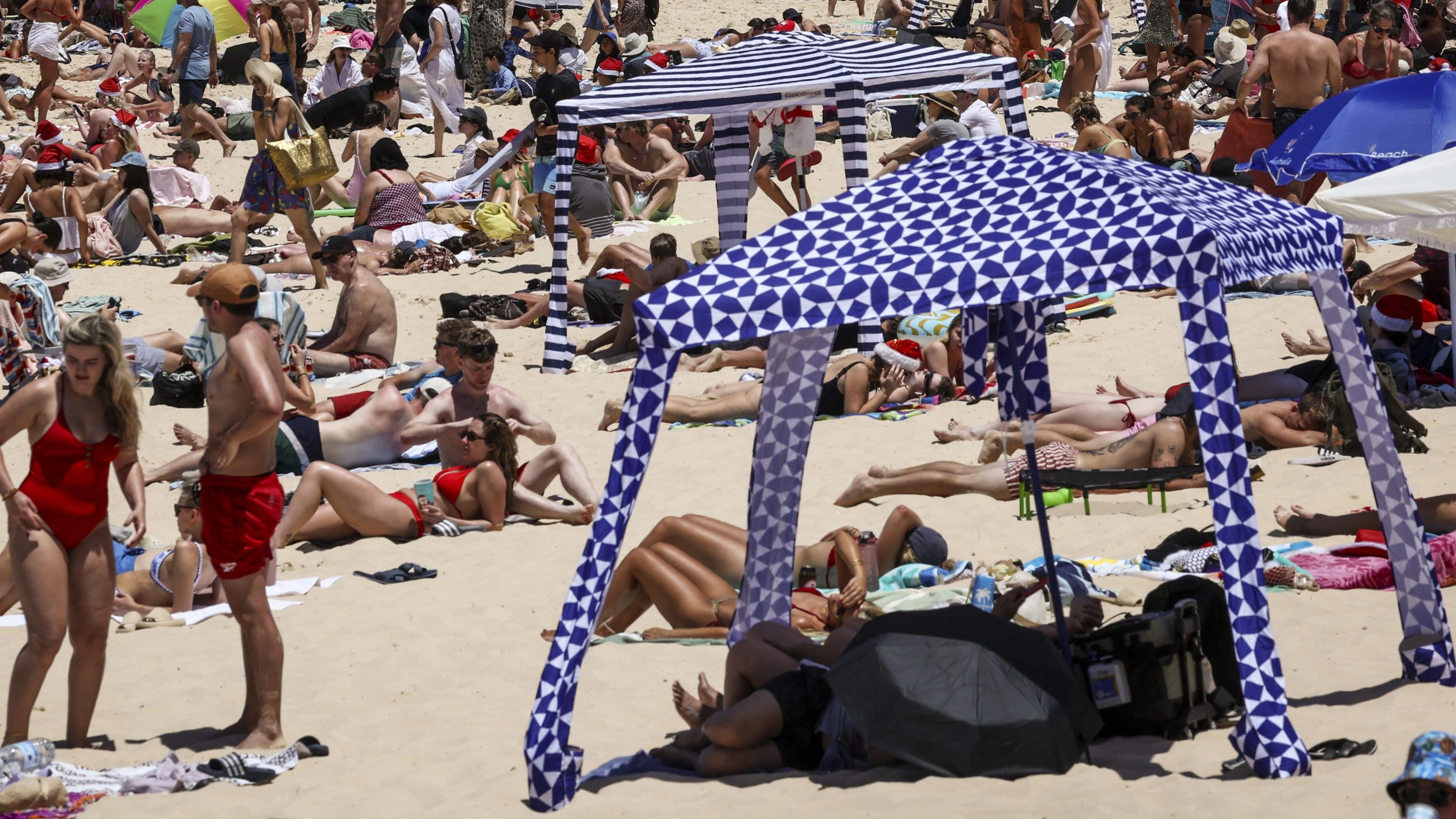 Beachgoers are seen on the sand on Christmas Day at Bondi Beach in Sydney on December 25, 2024.