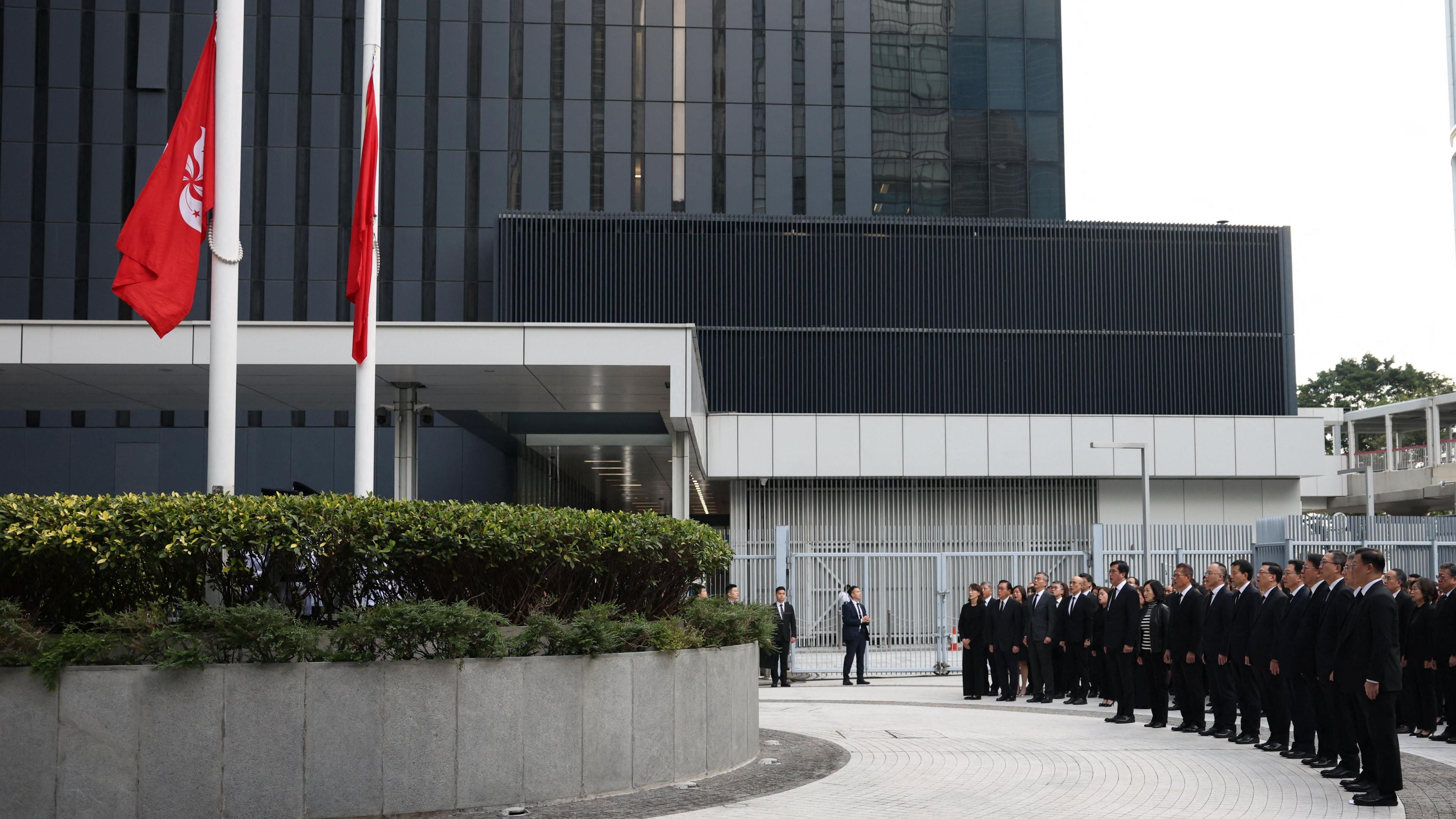 Officials attend a ceremony at Central Government Offices of Hong Kong to commemorate victims killed in the deadly fire at the Wang Fuk Court housing complex in Tai Po.