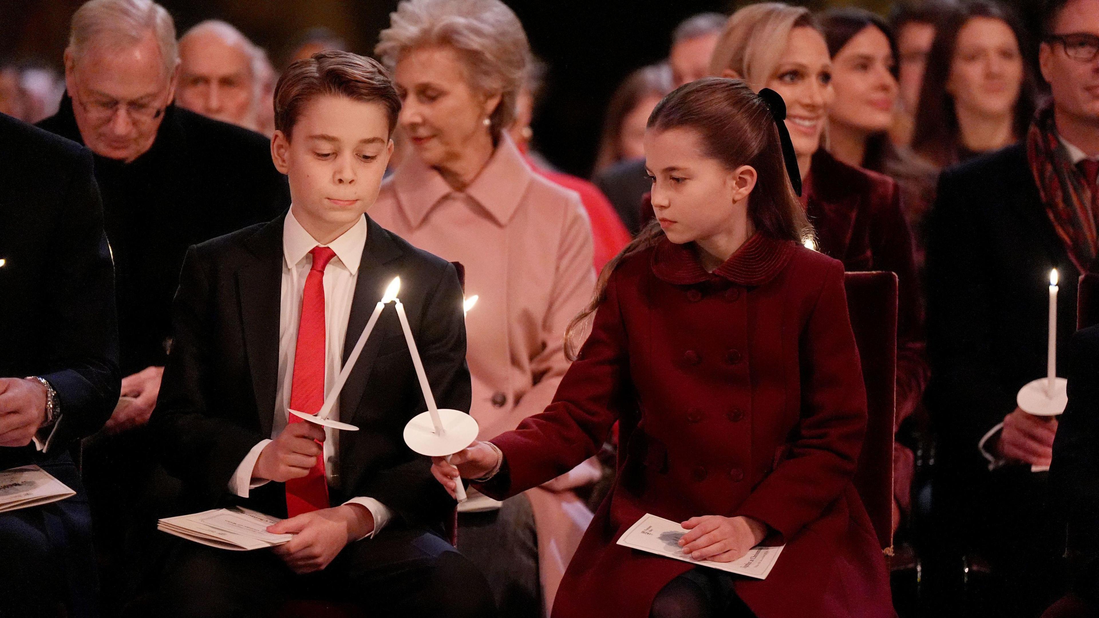 Prince George and Princess Charlotte place their candles together to light them for the service