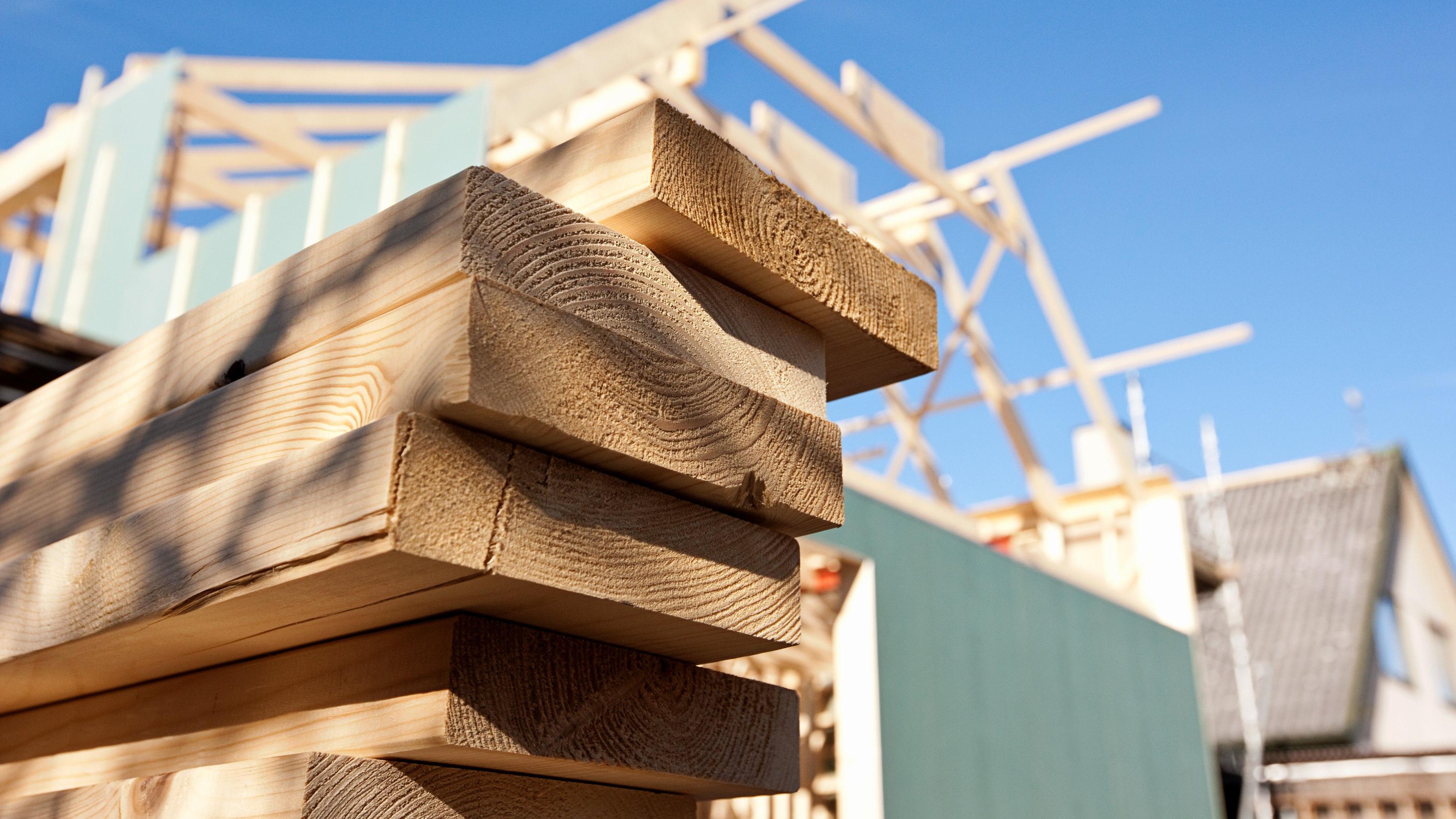 A close up of stacked wood on a building site.