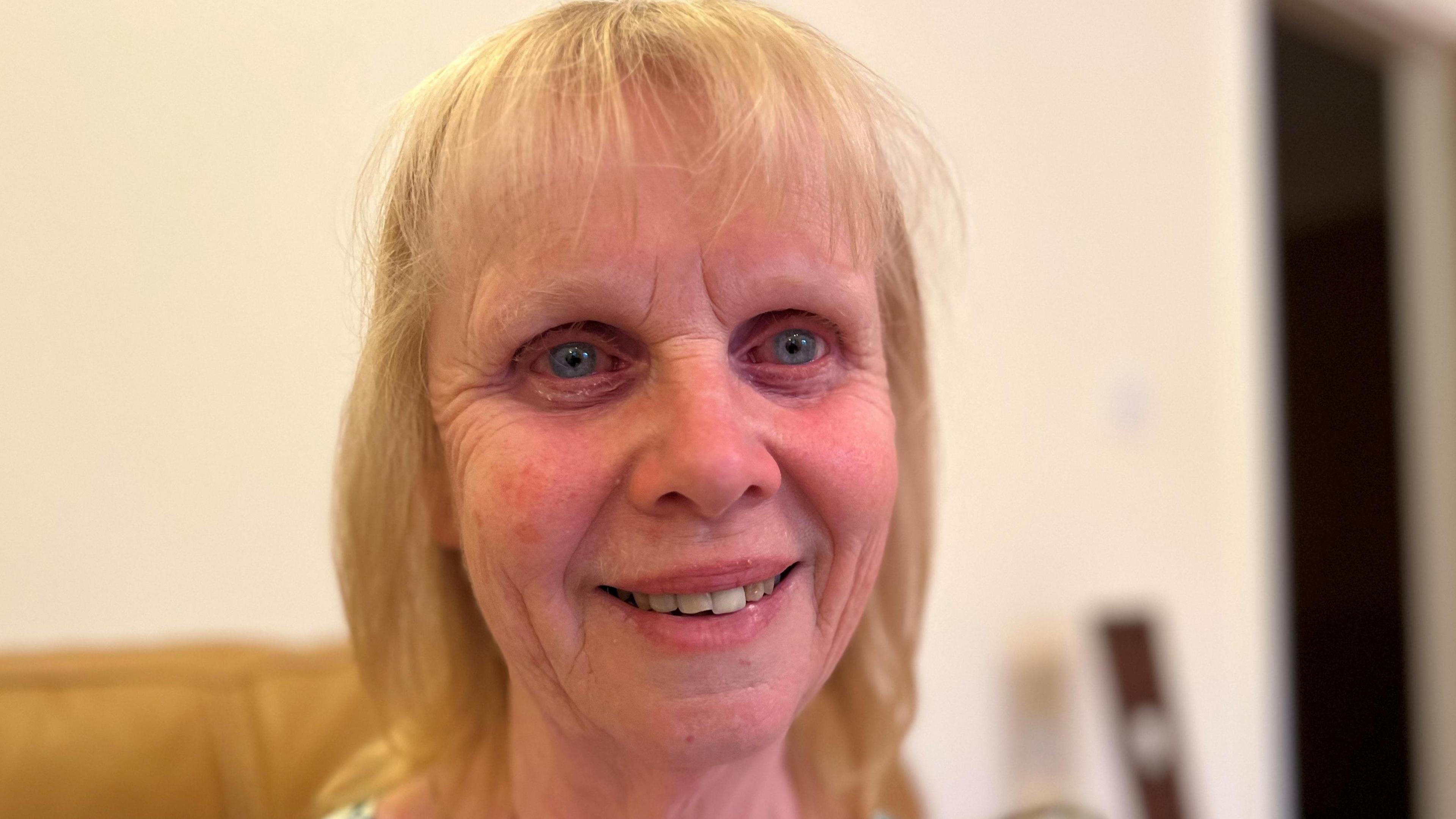 Fracking opponent Susan Halliday, photographed during an interview with the BBC. With light blonde hair and blue eyes, she is sitting on a gold-coloured sofa in her house in Preston New Road.