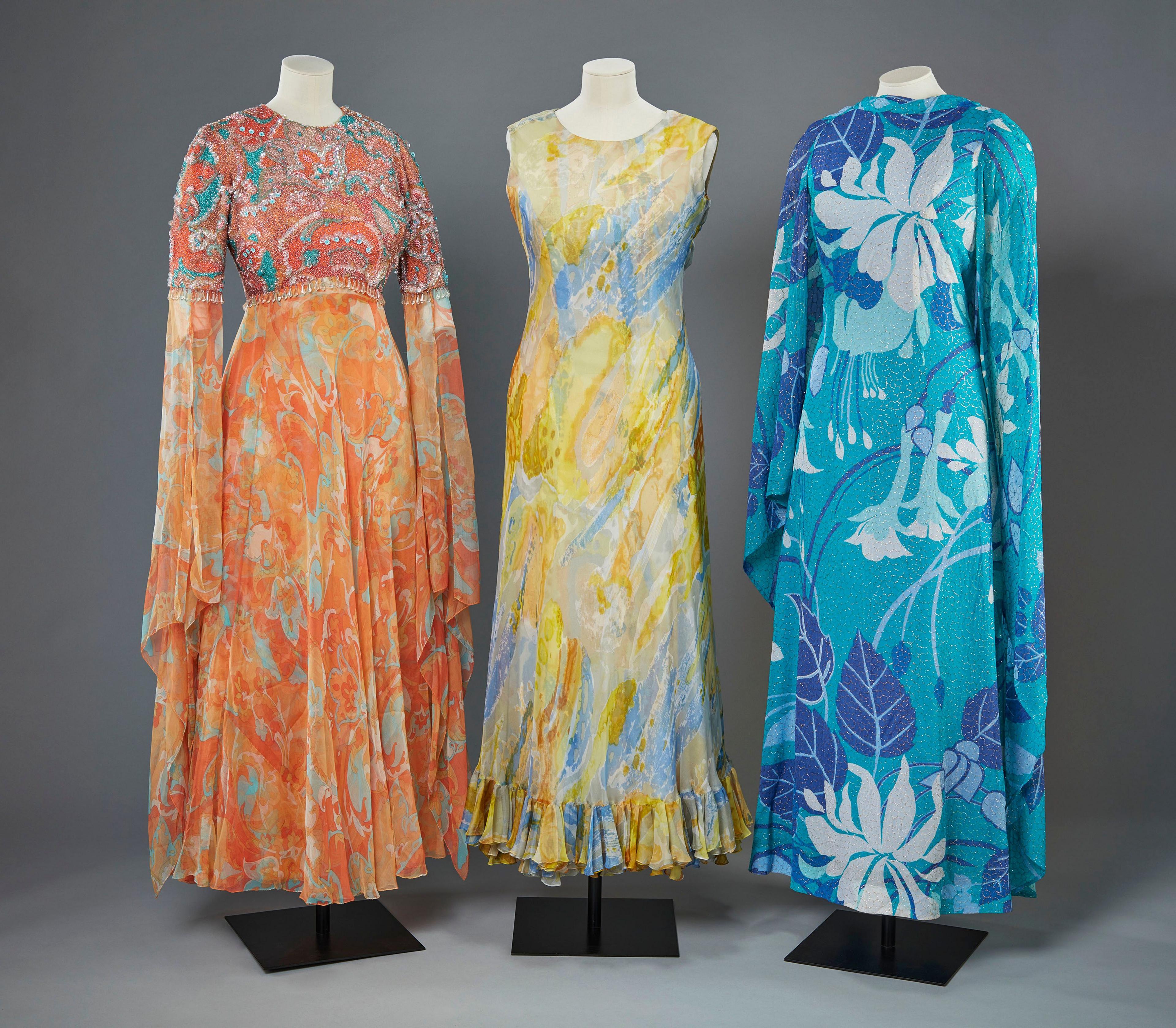 three dresses in bright colour tones and with abstract patterns on mannequins
