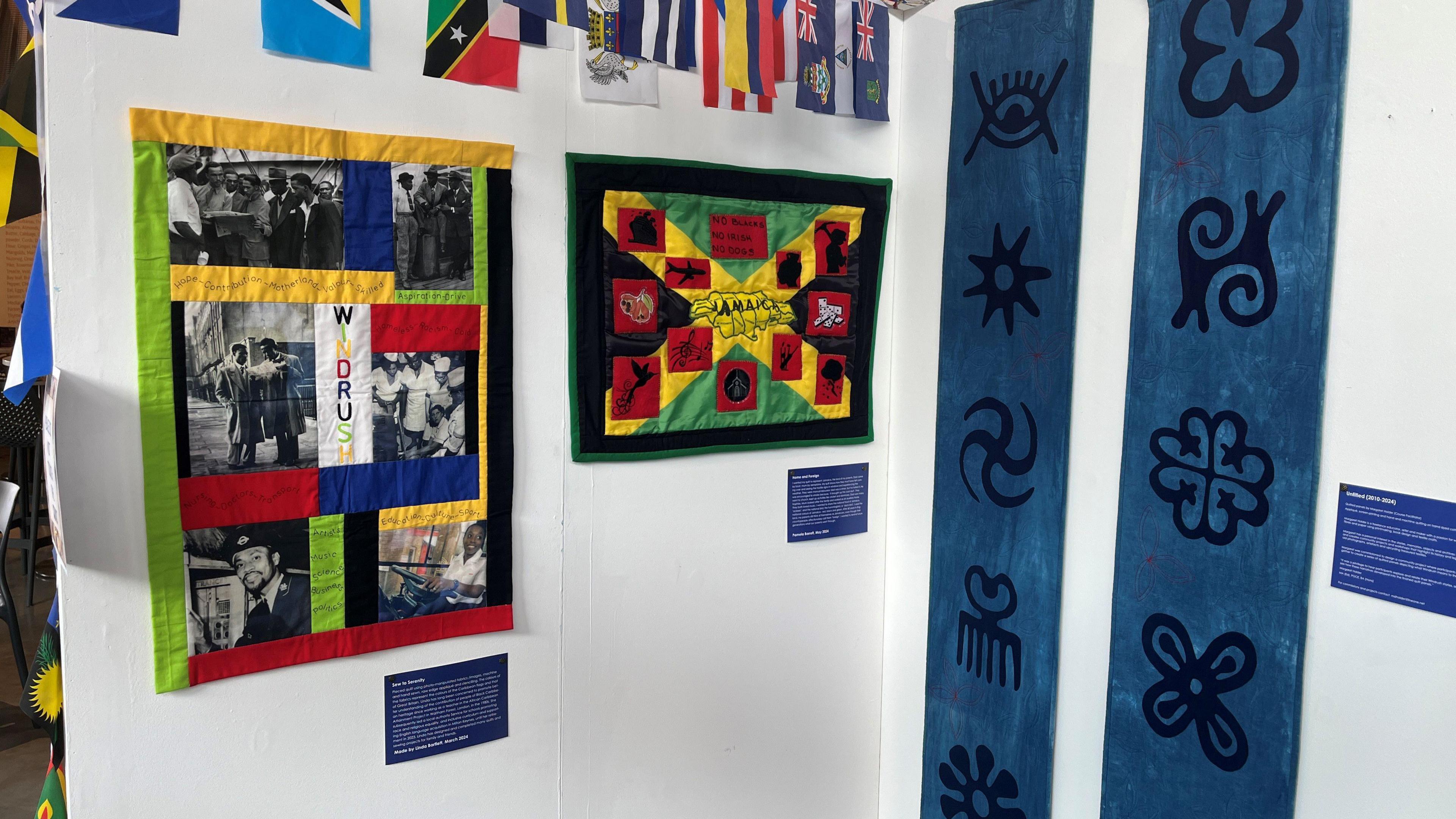 Several quilt son display boards with decorated cloth and flags