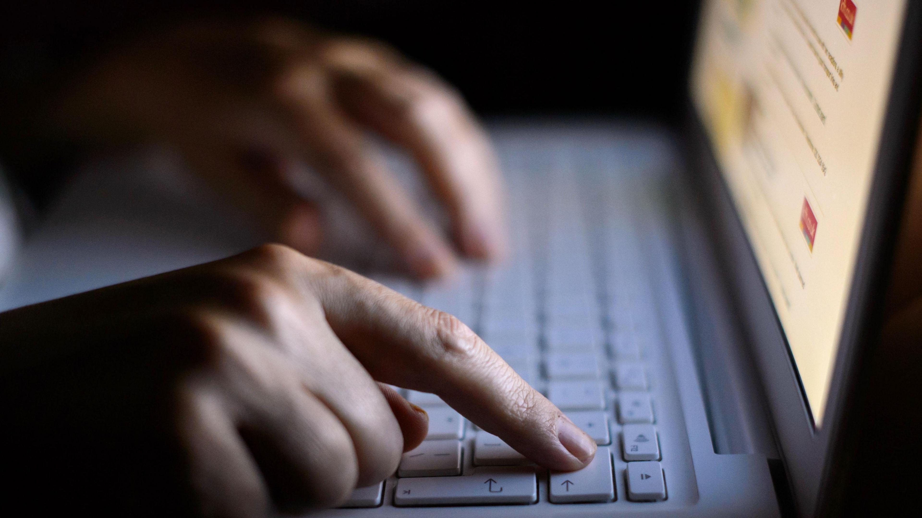 Person using a laptop computer keyboard