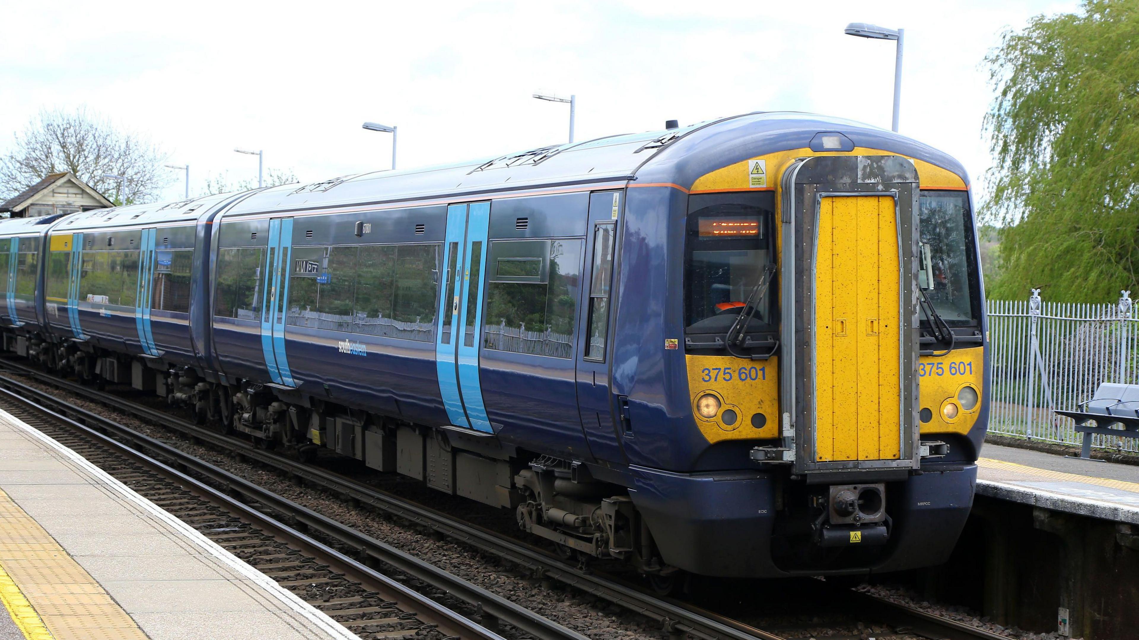 A dark blue Southeastern class 375 train passing through Wye station in Kent