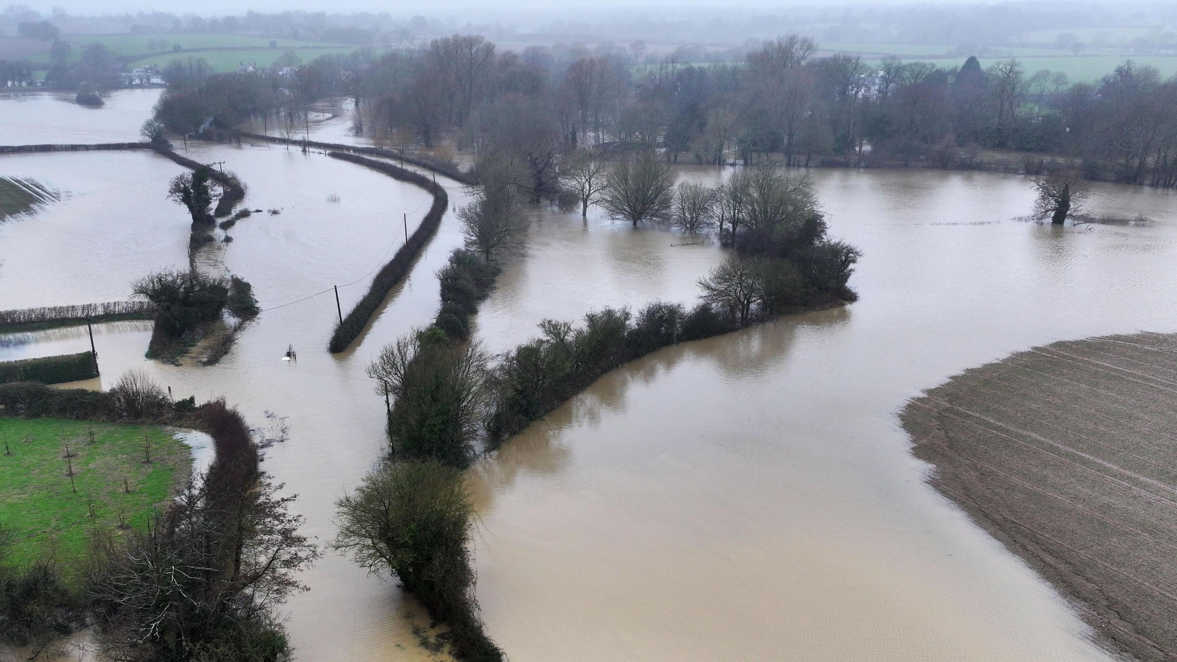 The flooded area around Barcombe Mills Road in Lewes, East Sussex, following huge rainfall on Sunday 5 January. Water has risen up in a number of fields and a number of trees and bushes can be seen peaking out from the flooded area.