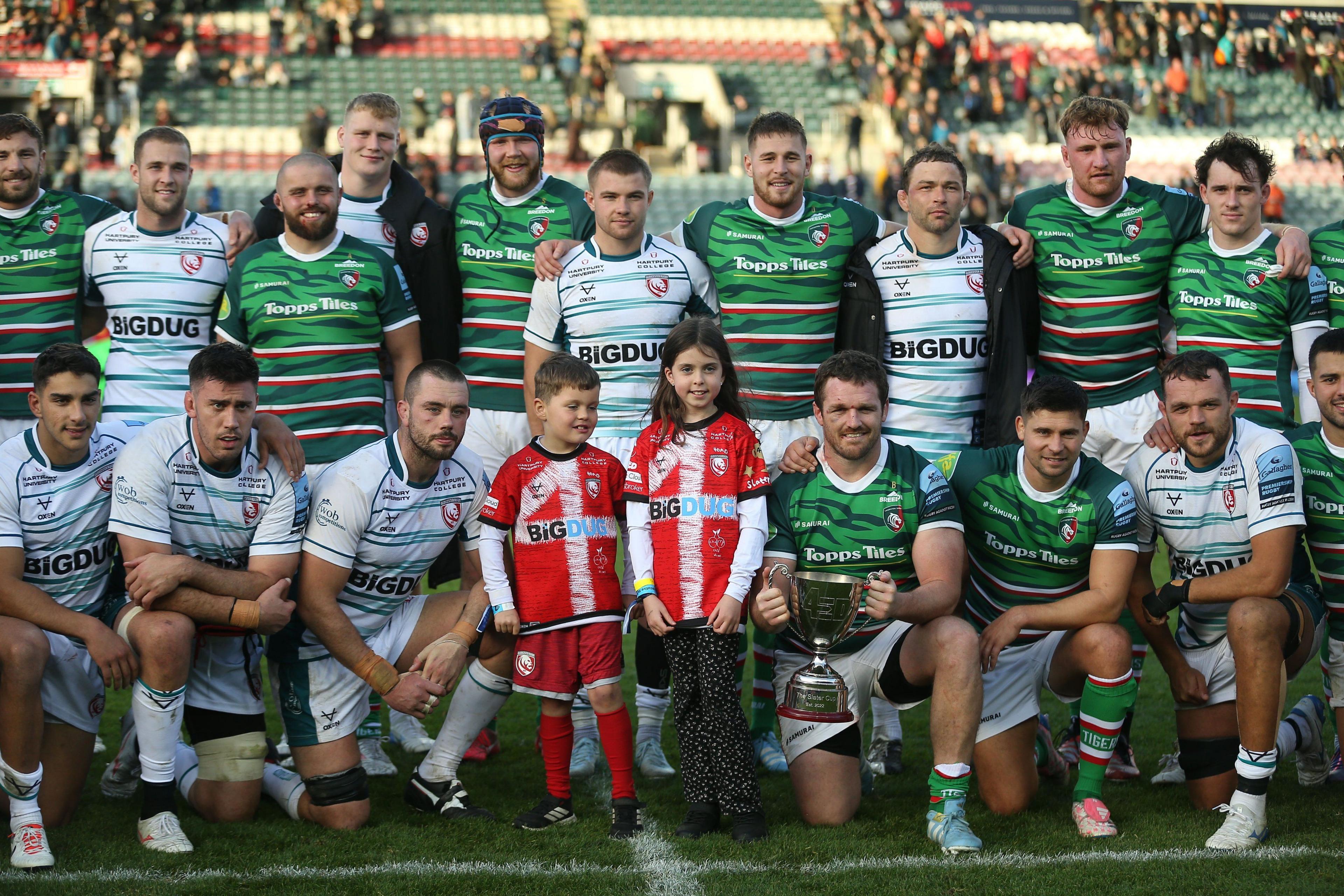 Gloucester and Leicester rugby players pose for a photo with the children of Ed Slater.