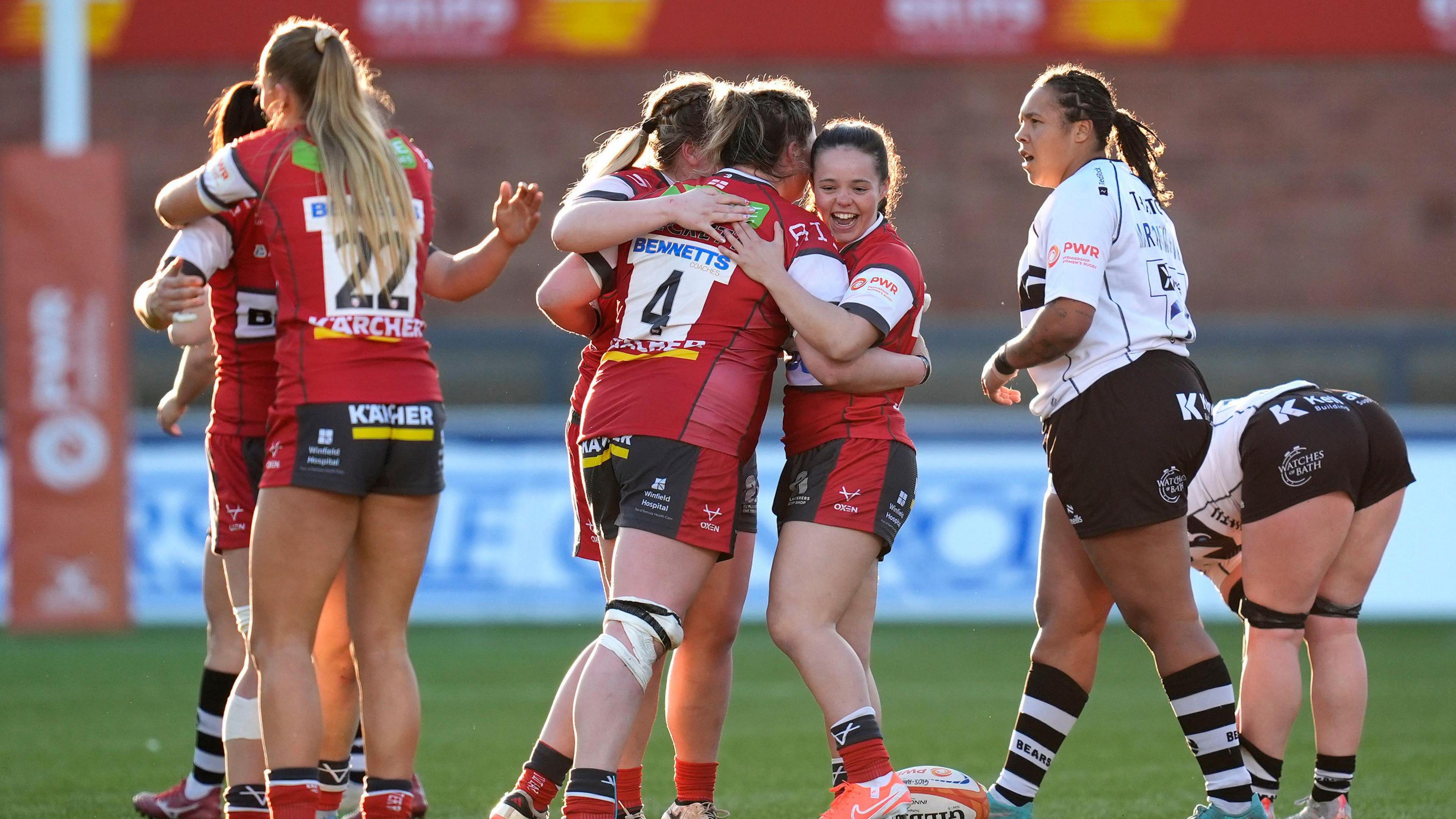 Gloucester-Hartpury players celebrate victory by embracing each other on the pitch after beating Bristol Bears at Kingsholm in Premiership Women's Rugby semi-final match at Kingsholm