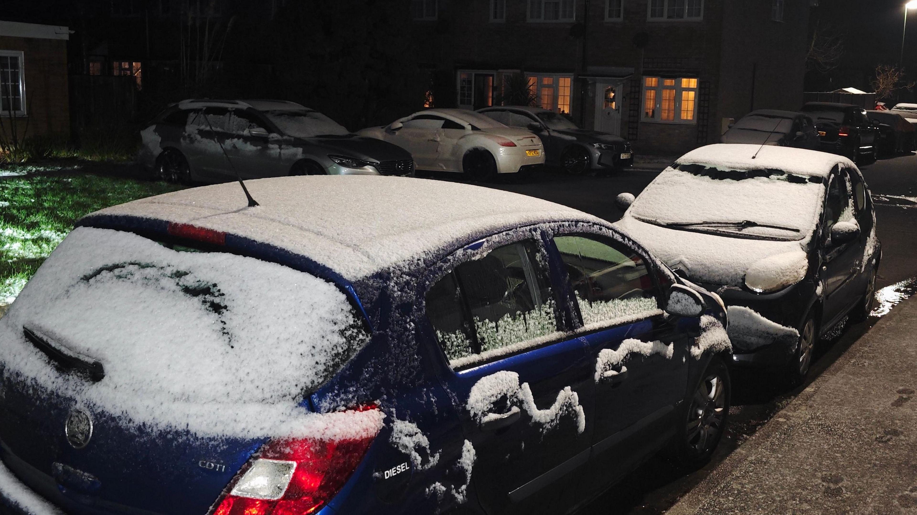 Snow on cars in forefront and background 