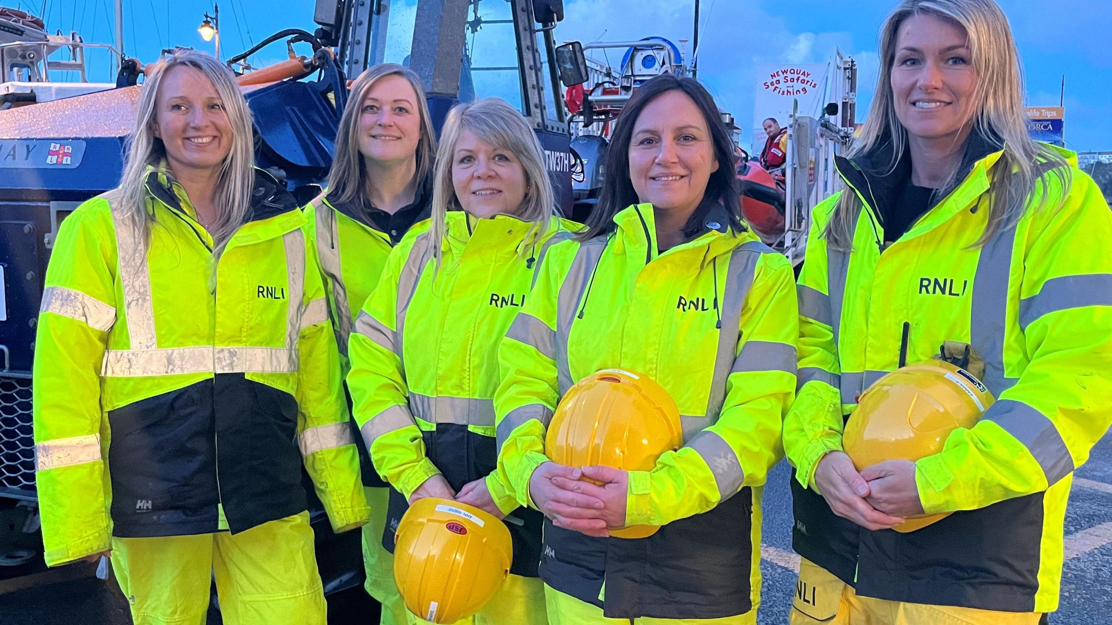 Five female shore crew by the lifeboat