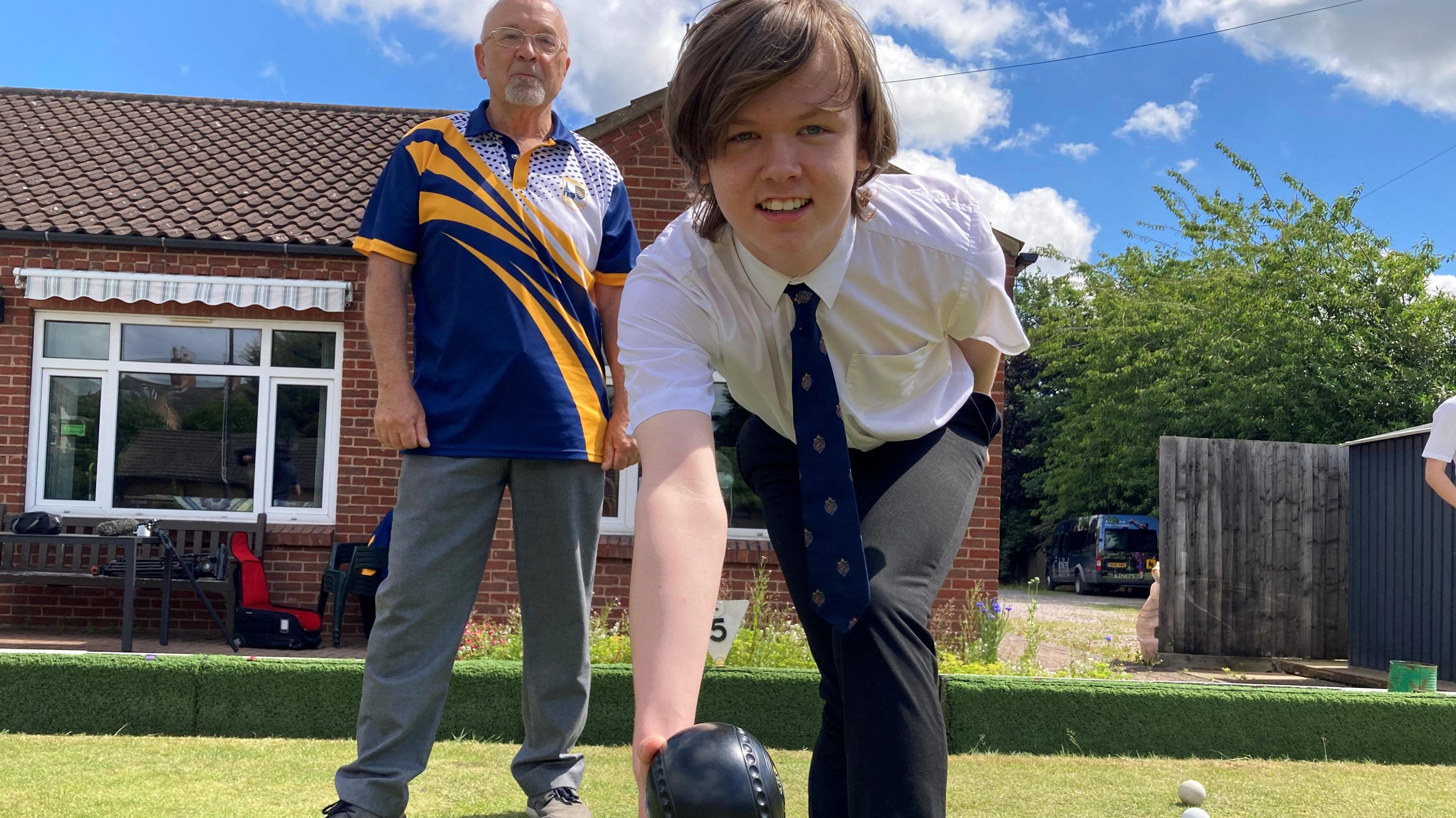 A student leans down to bowl 