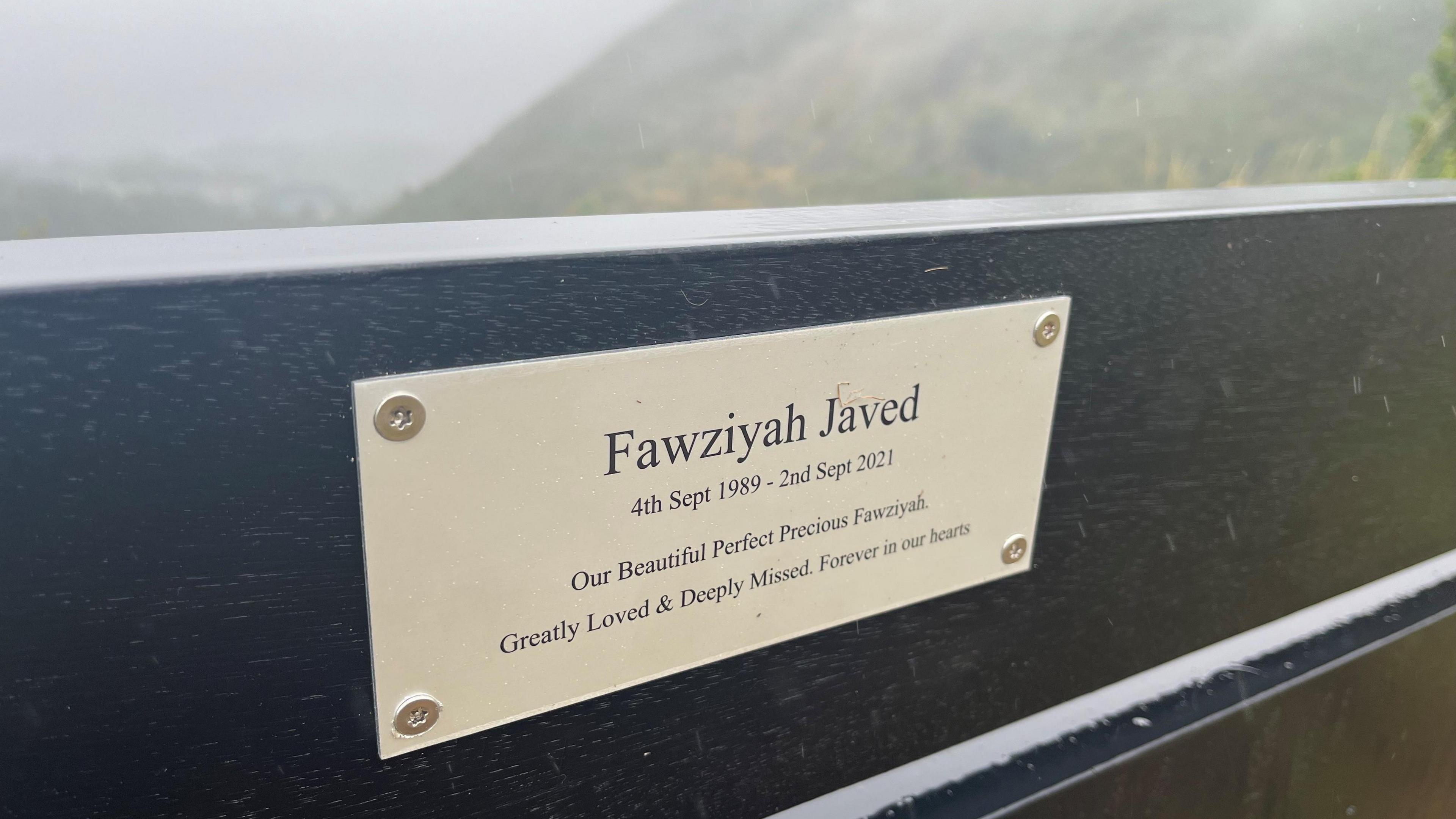 A plaque showing Fawziyah Javed's name on the memorial bench 