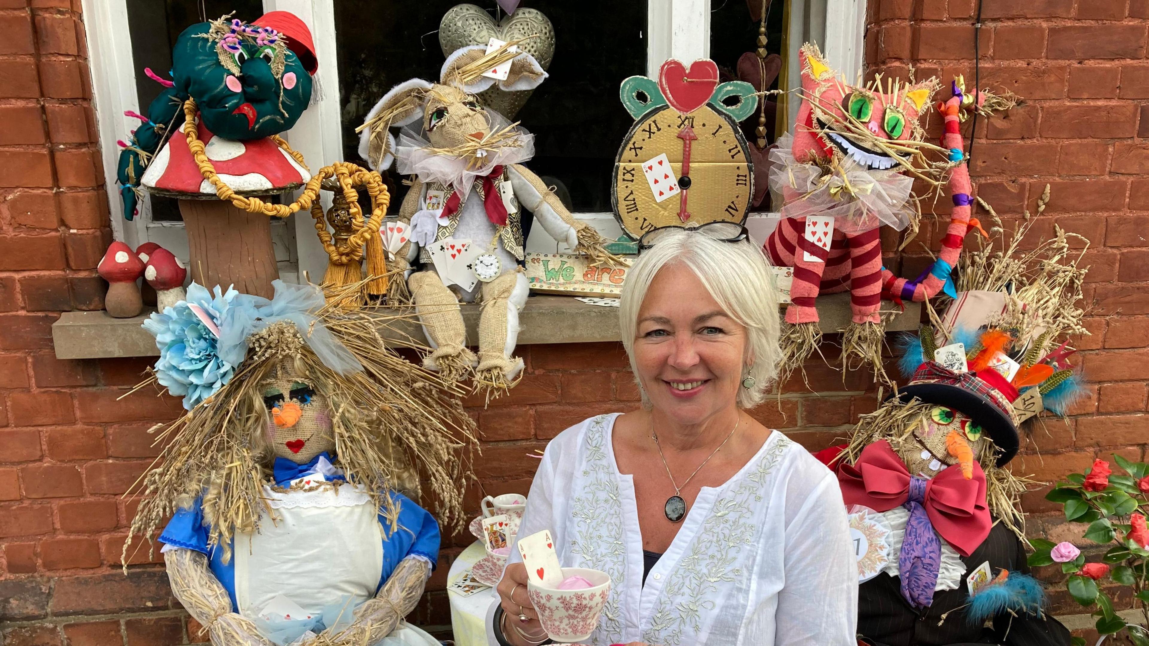 Jo Byford sits among her Alice in Wonderland scarecrow scene that she has entered into the Cavendish Scarecrow Festival  