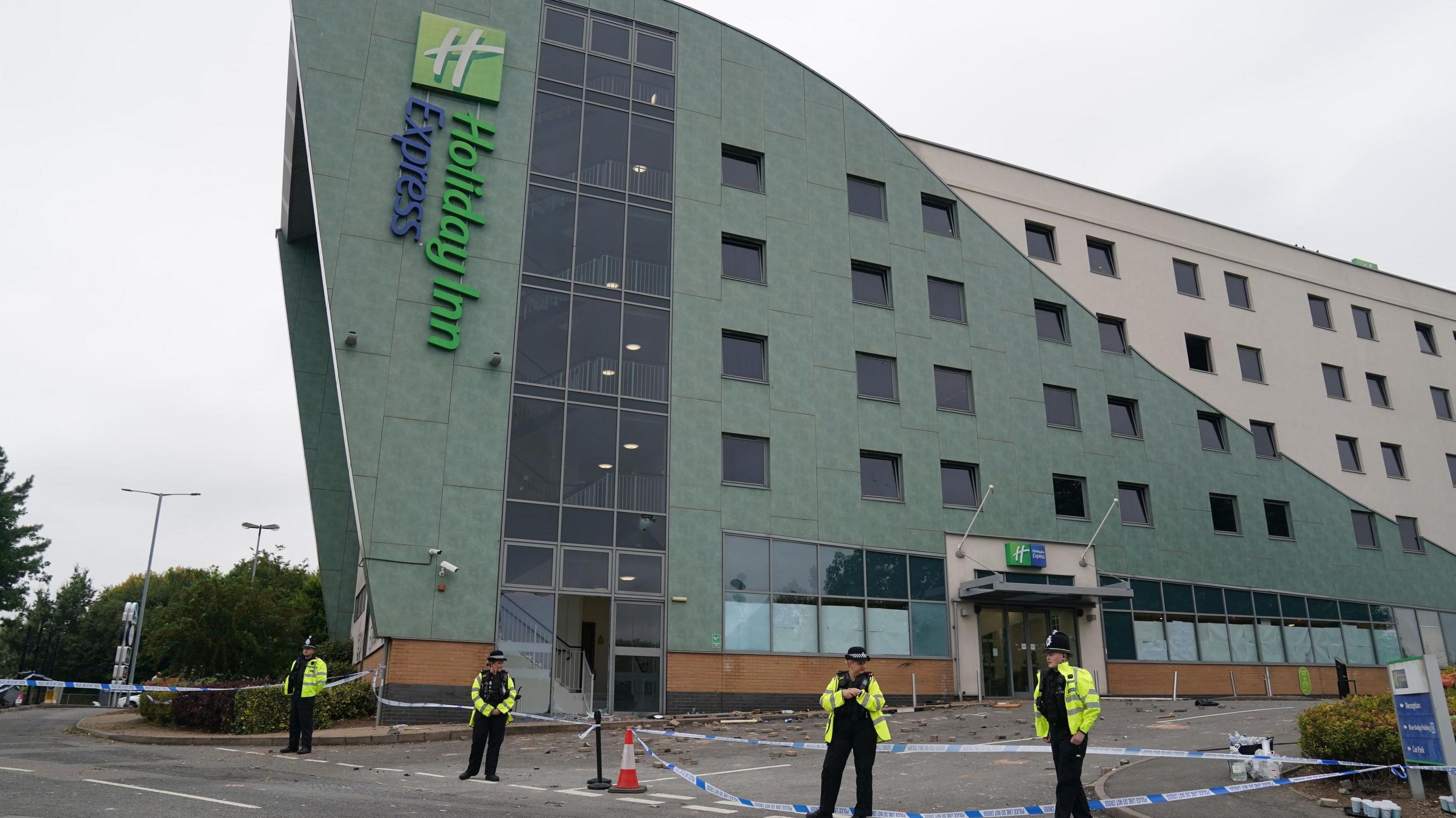 Police officers at the Holiday Inn Express in Tamworth, Staffordshire, after a mob attacked on 5 August.