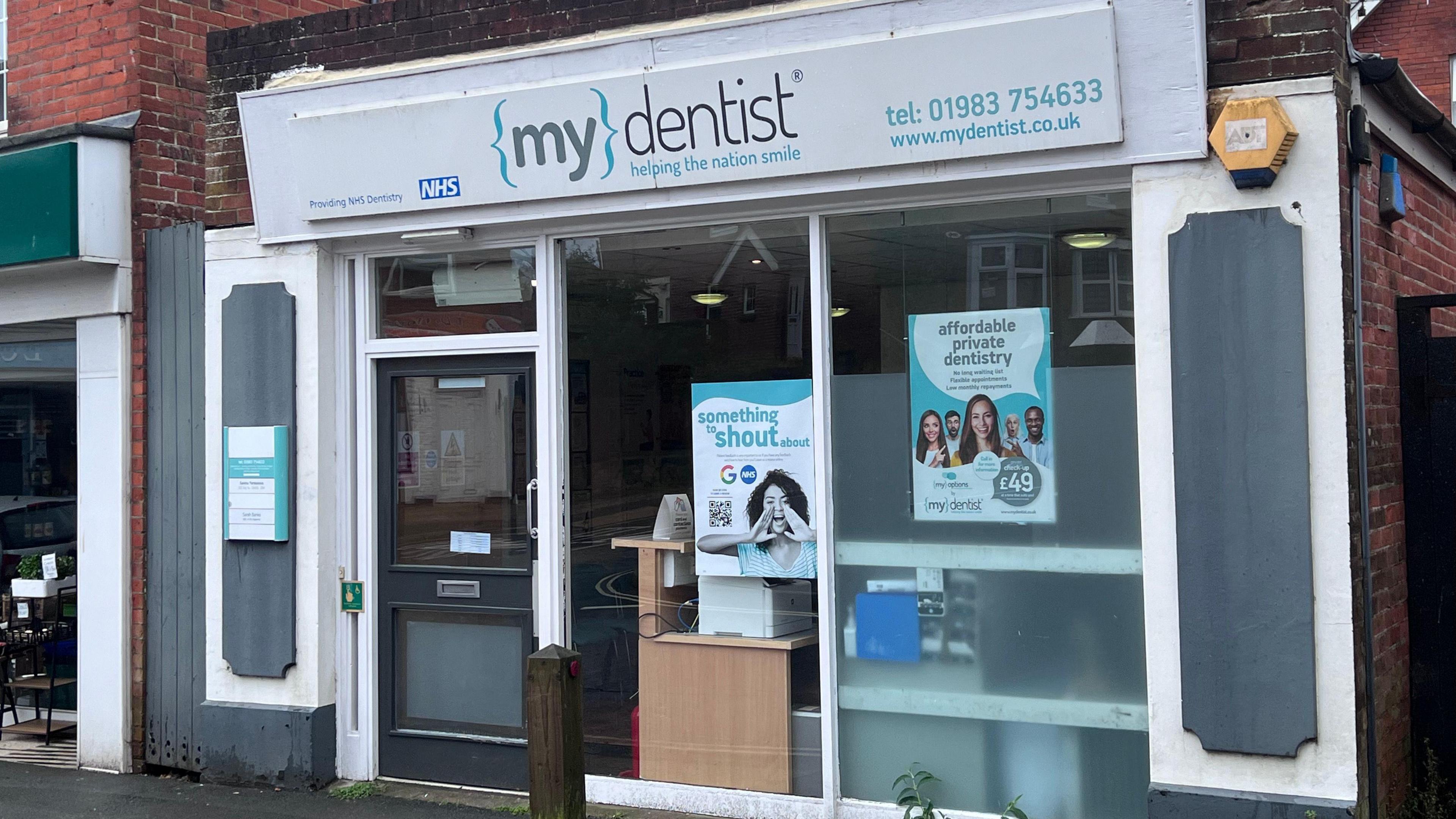 The outside of a dental practice mydentist which has a sign saying "provides NHS treatment"