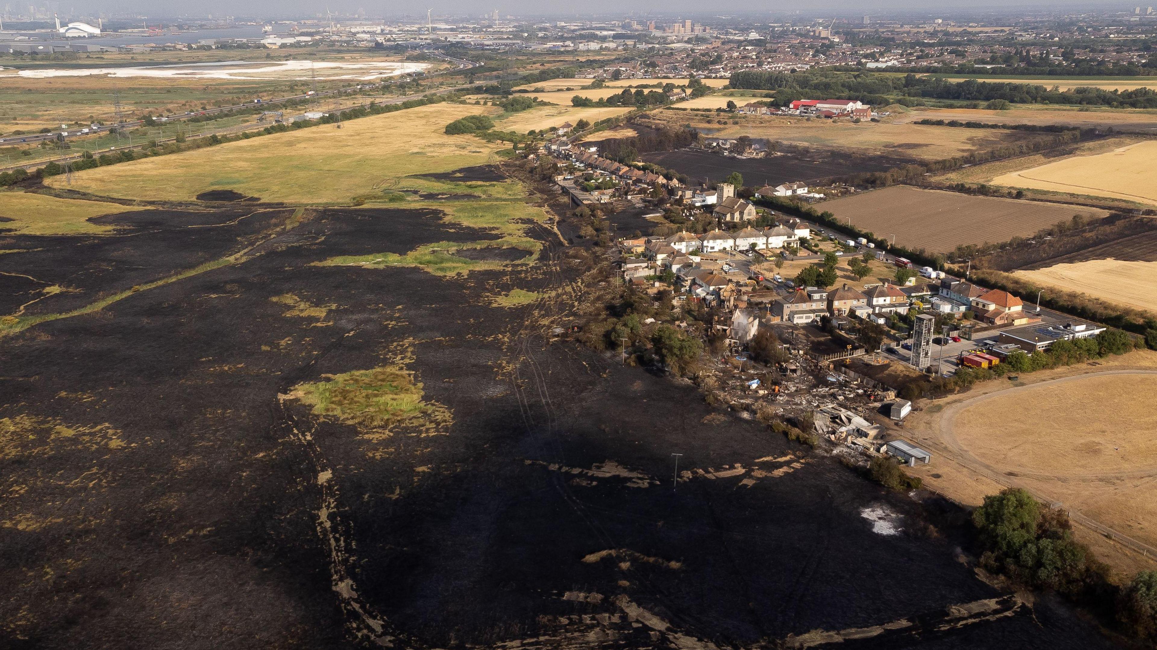 Charred earth surrounds a village in East London