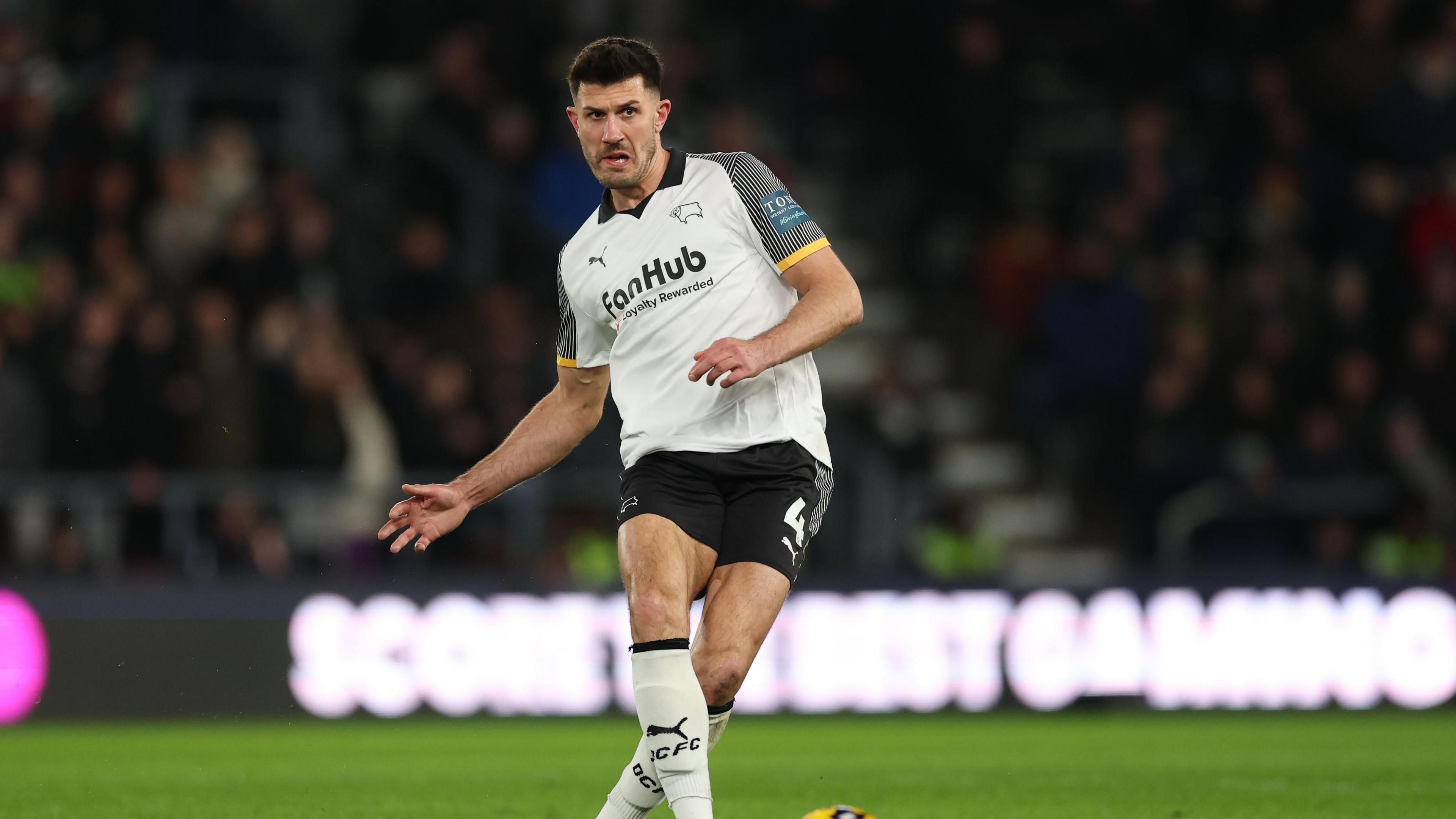 Danny Batth, wearing Derby County's white and black home kit, playing football during the side's match against West Bromwich Albion in January