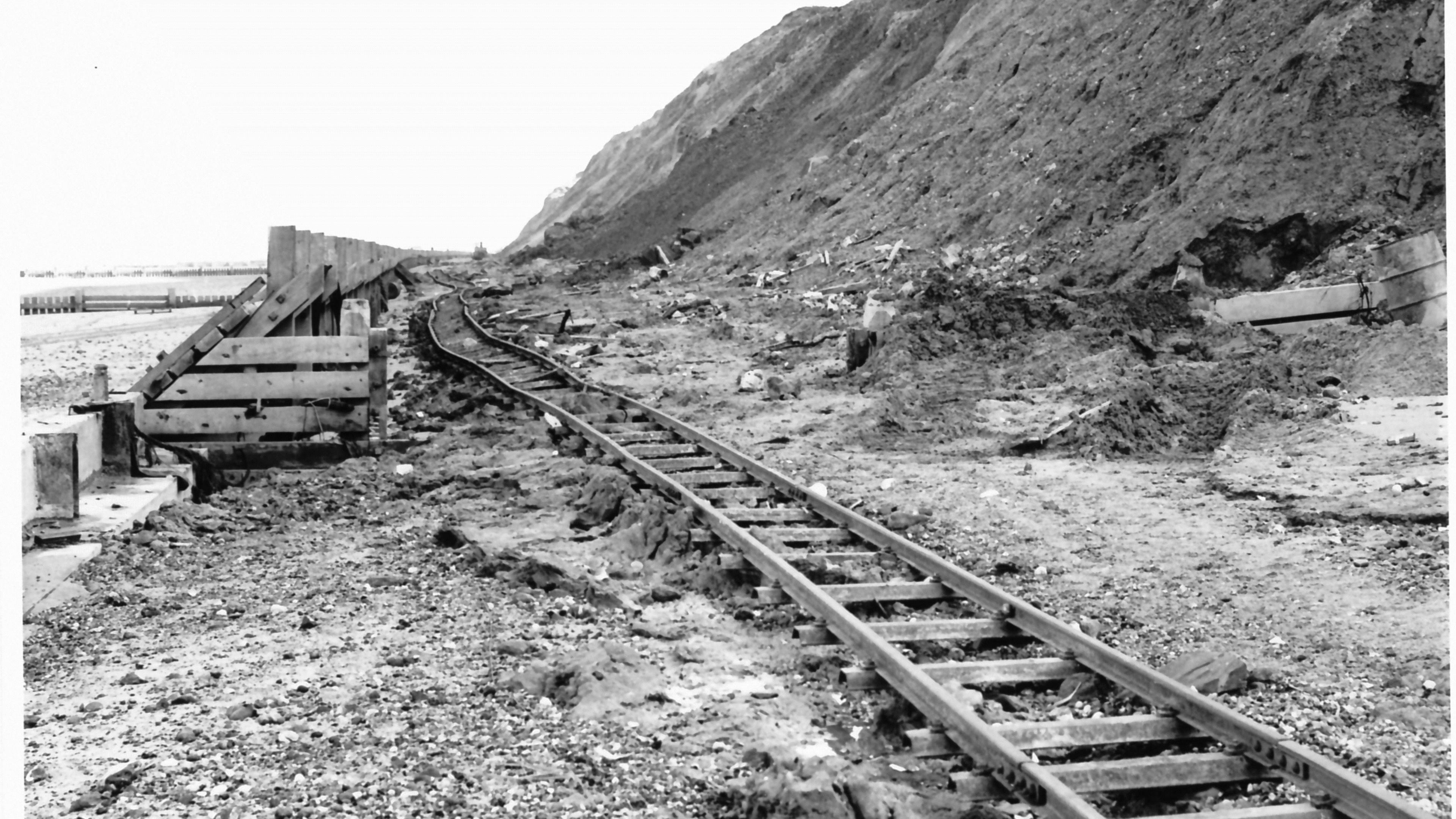 A photo taken in 1973 shows a railway track running behind coastal flood revetments