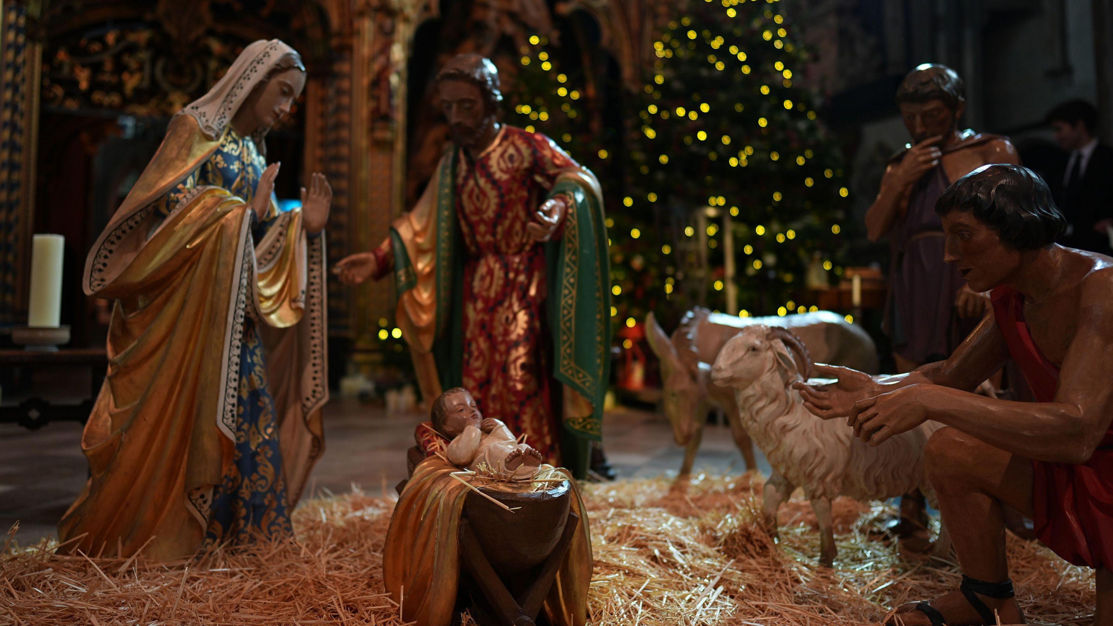 Nativitity figurines depicting baby Jesus in a barn