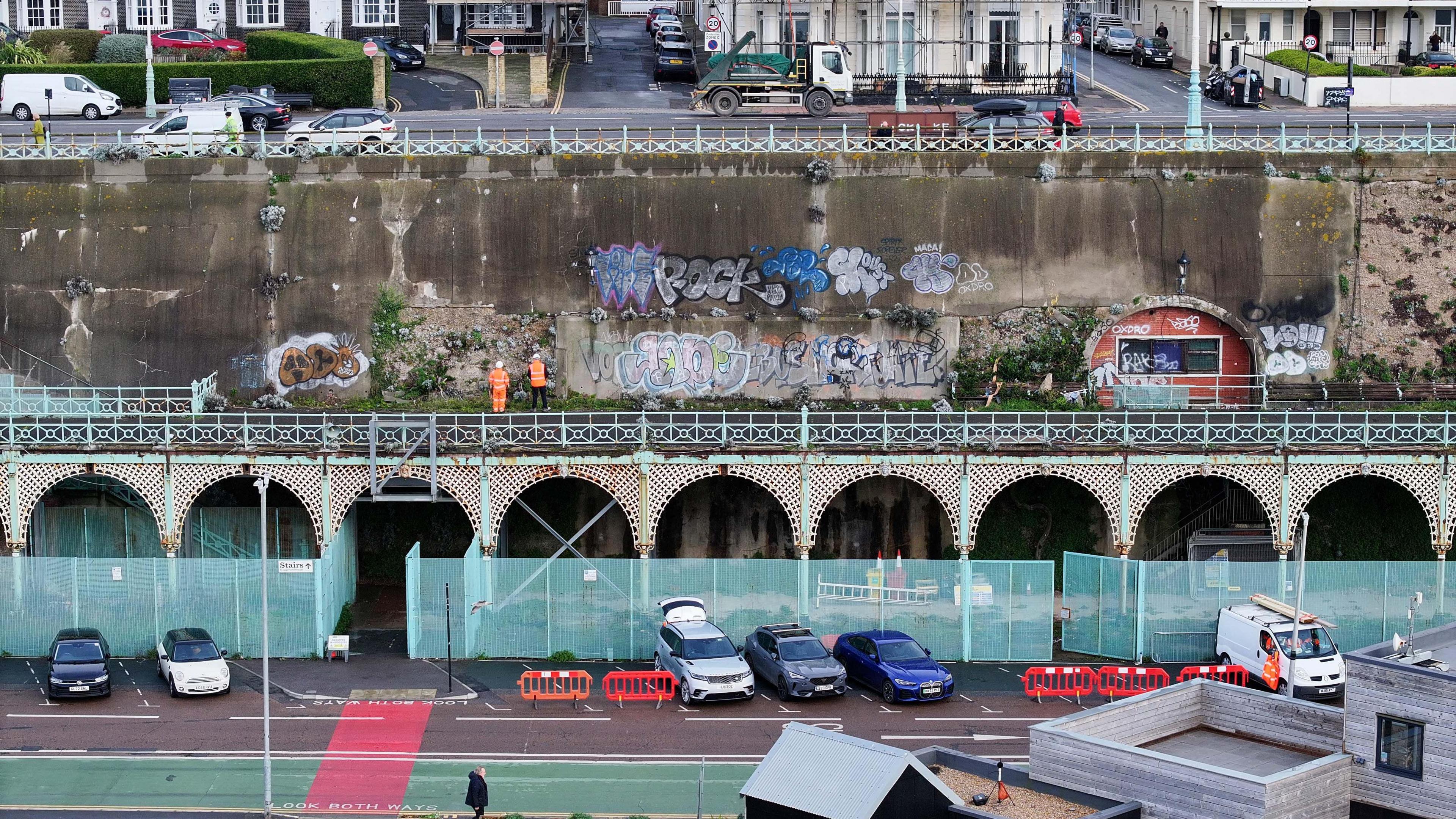 A high up shot of the terrace with two workers standing on it. The bottom of the terrace has fences covering it up