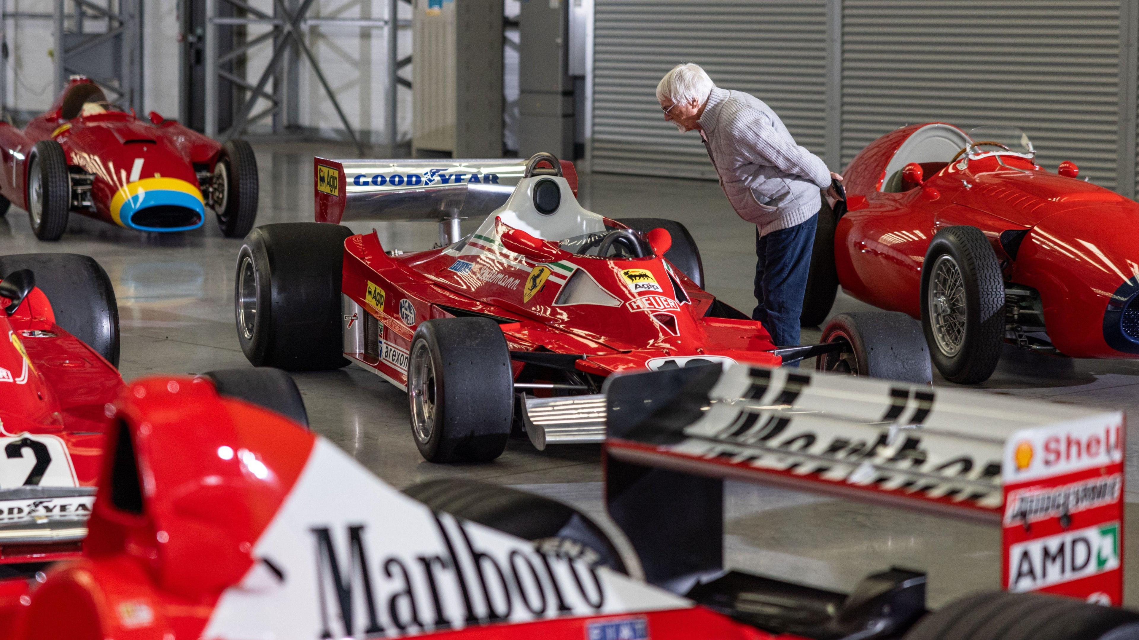 Former Formula 1 boss Bernie Ecclestone looks at one of the Ferrari cars in his collection. 