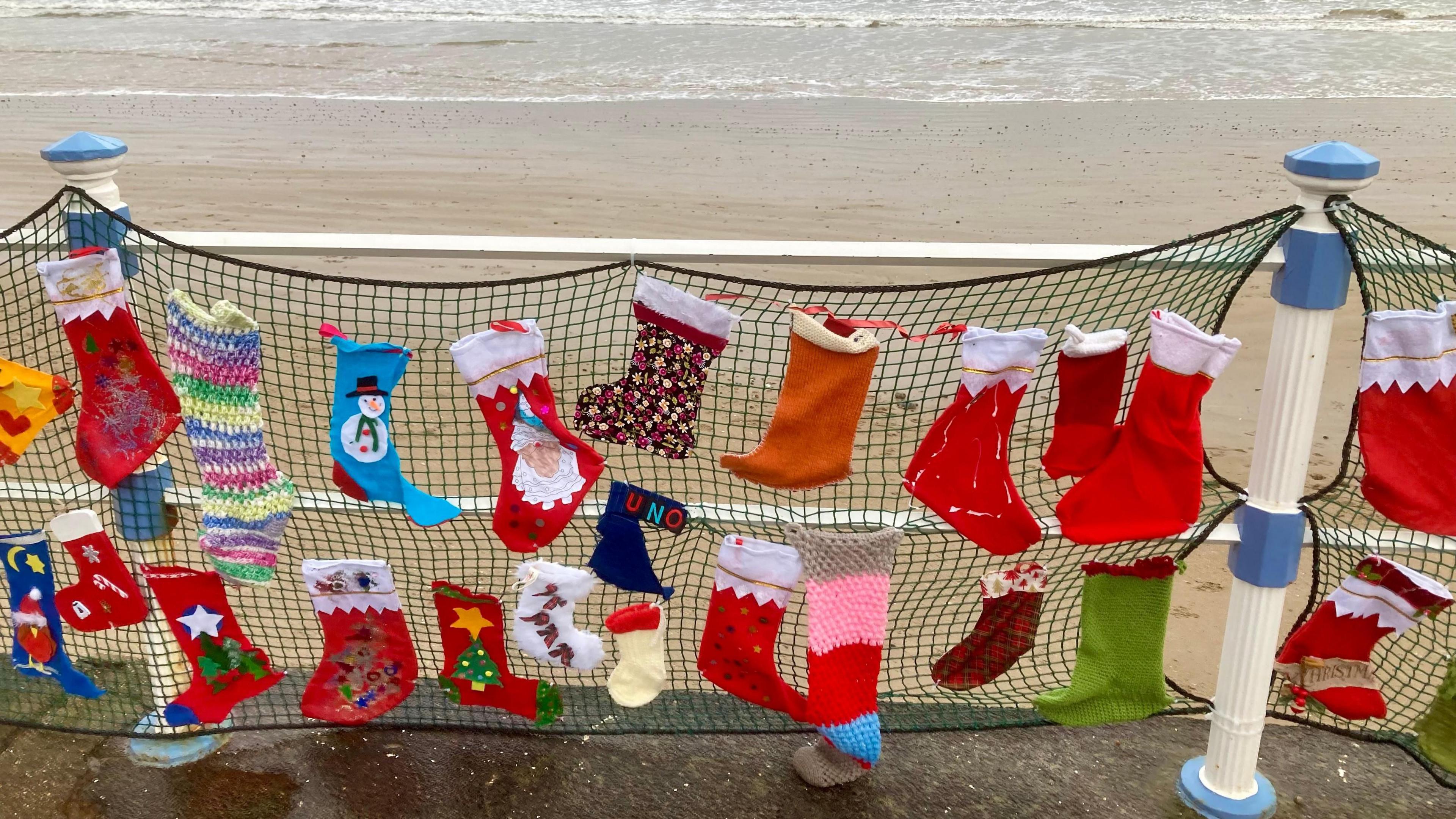 The beach promenade at Weymouth, Dorset, strung with netting and filled with Christmas Stockings to highlight the need for foster carers.