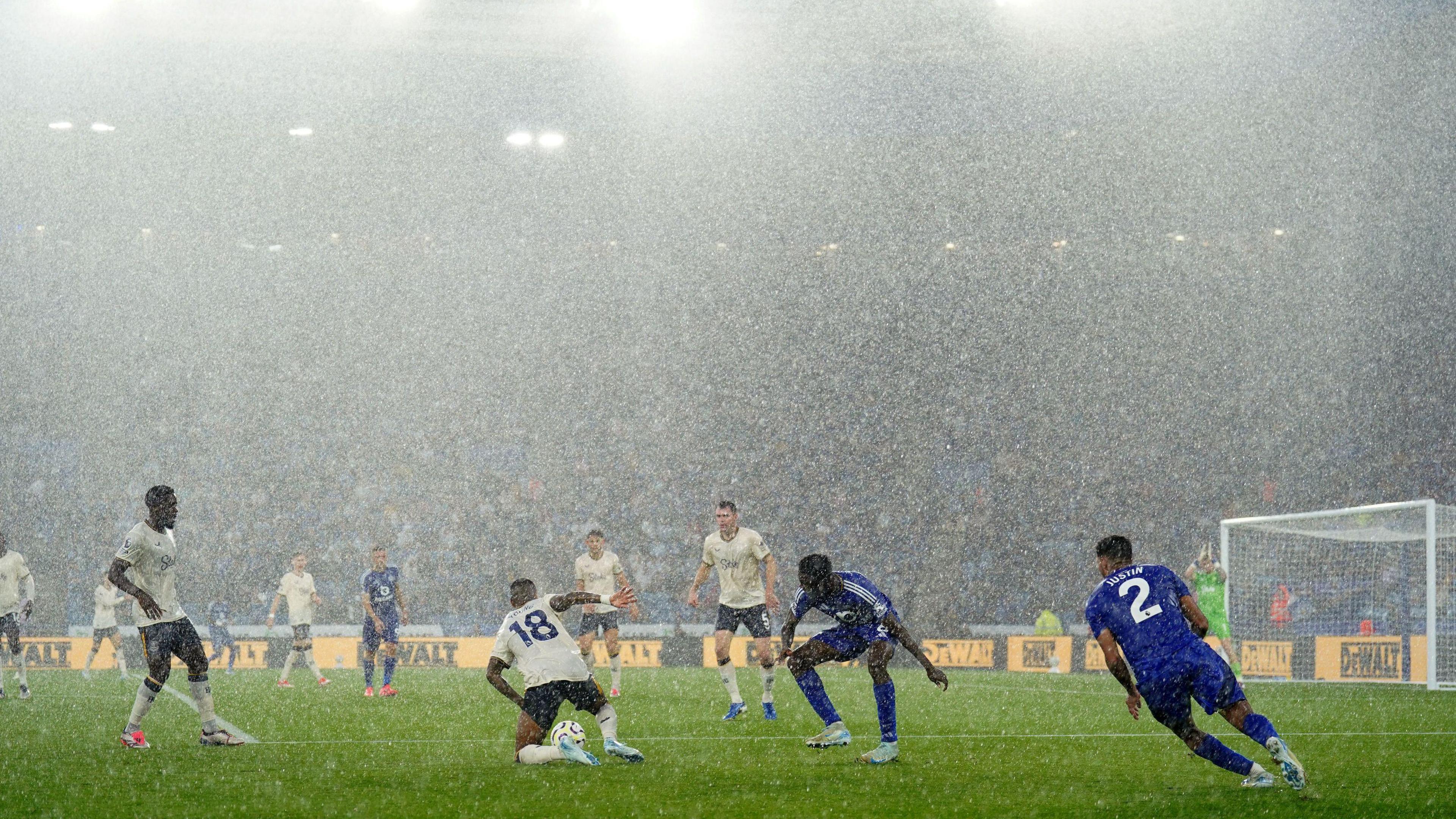 Leicester city and Everton playing football in heavy rain