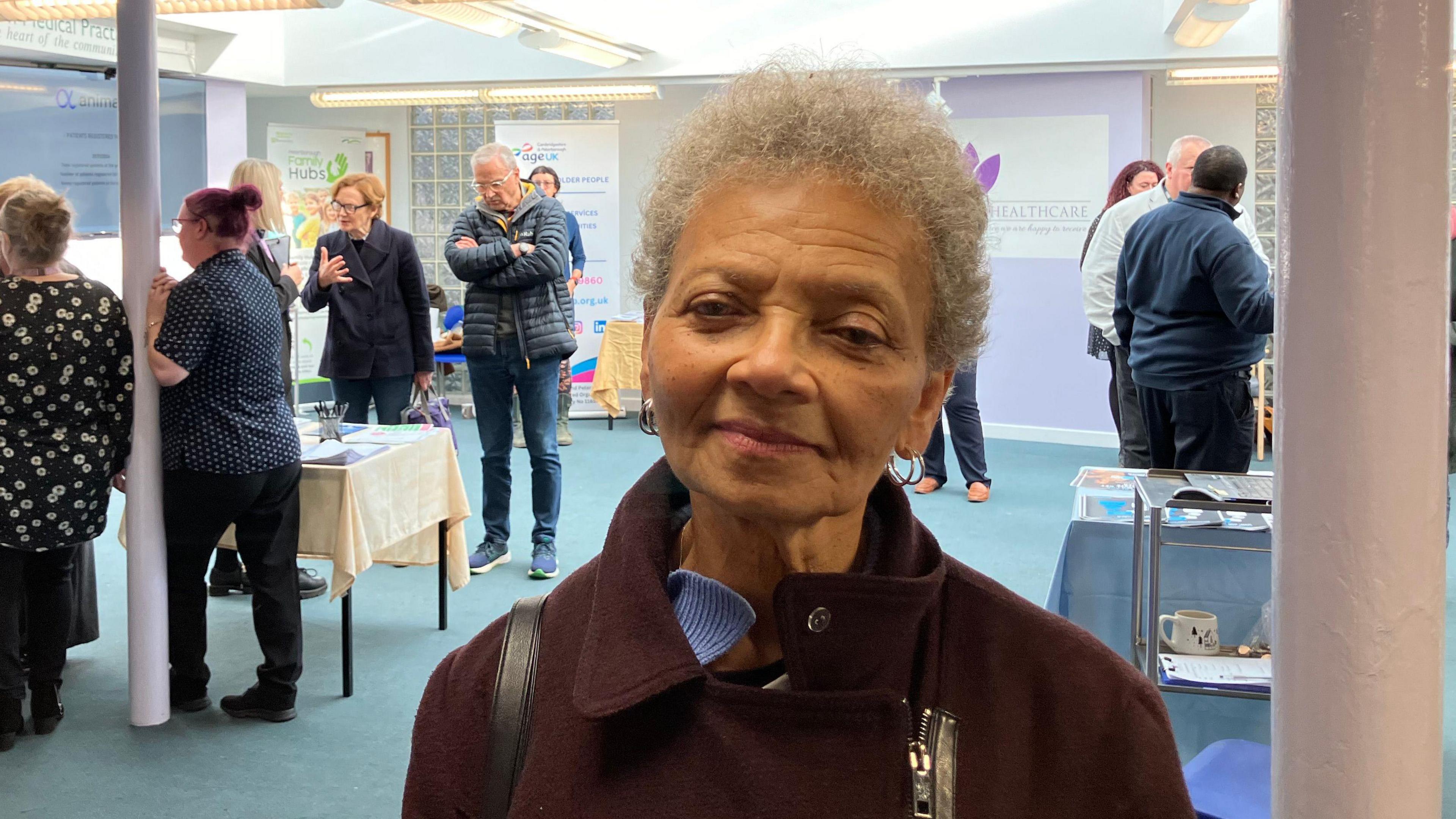 Valery Matton wearing a burgundy coat, smiling for the camera.