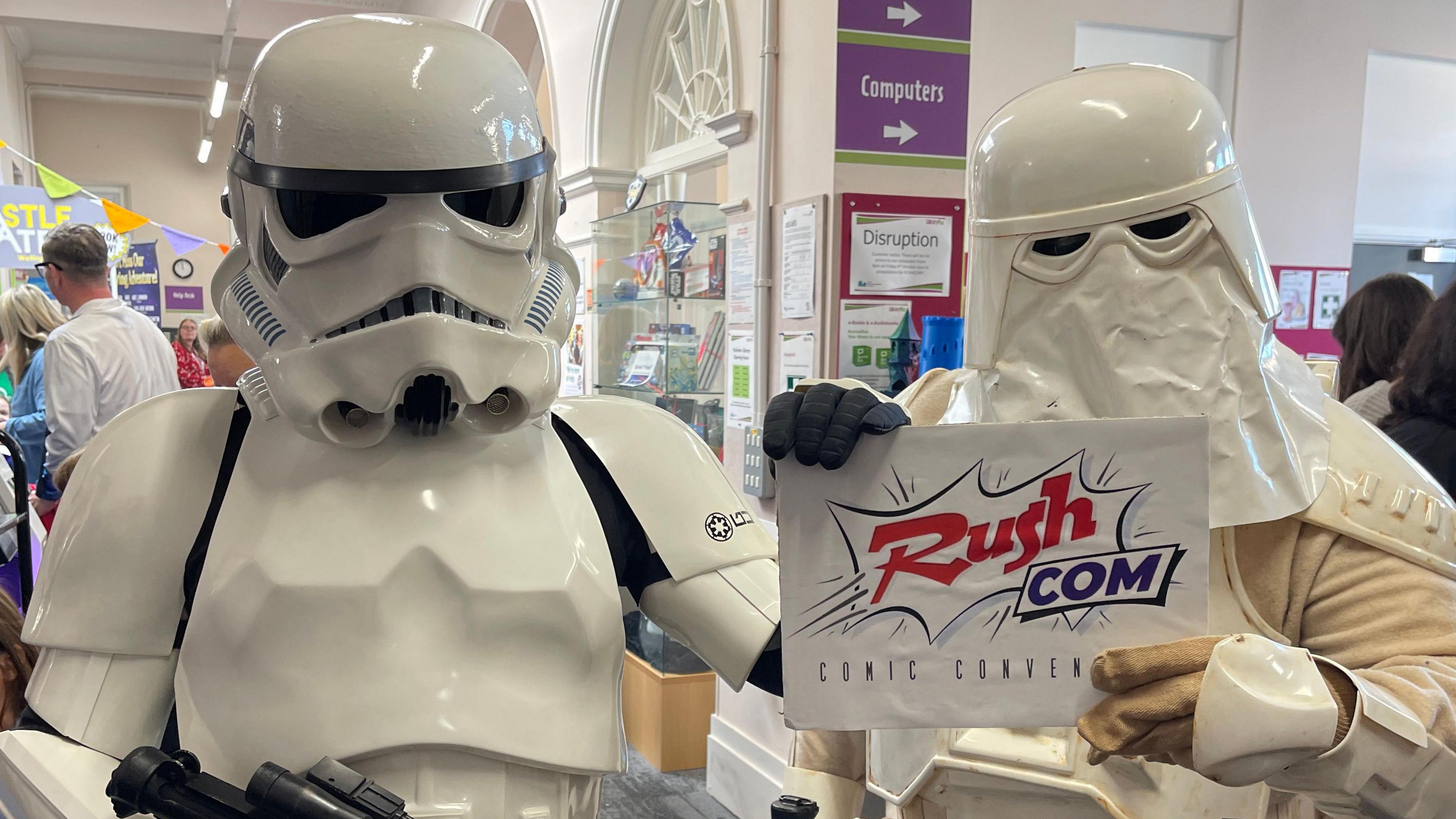 Two storm troopers. Dressed both in white and holding a RushCom sign.