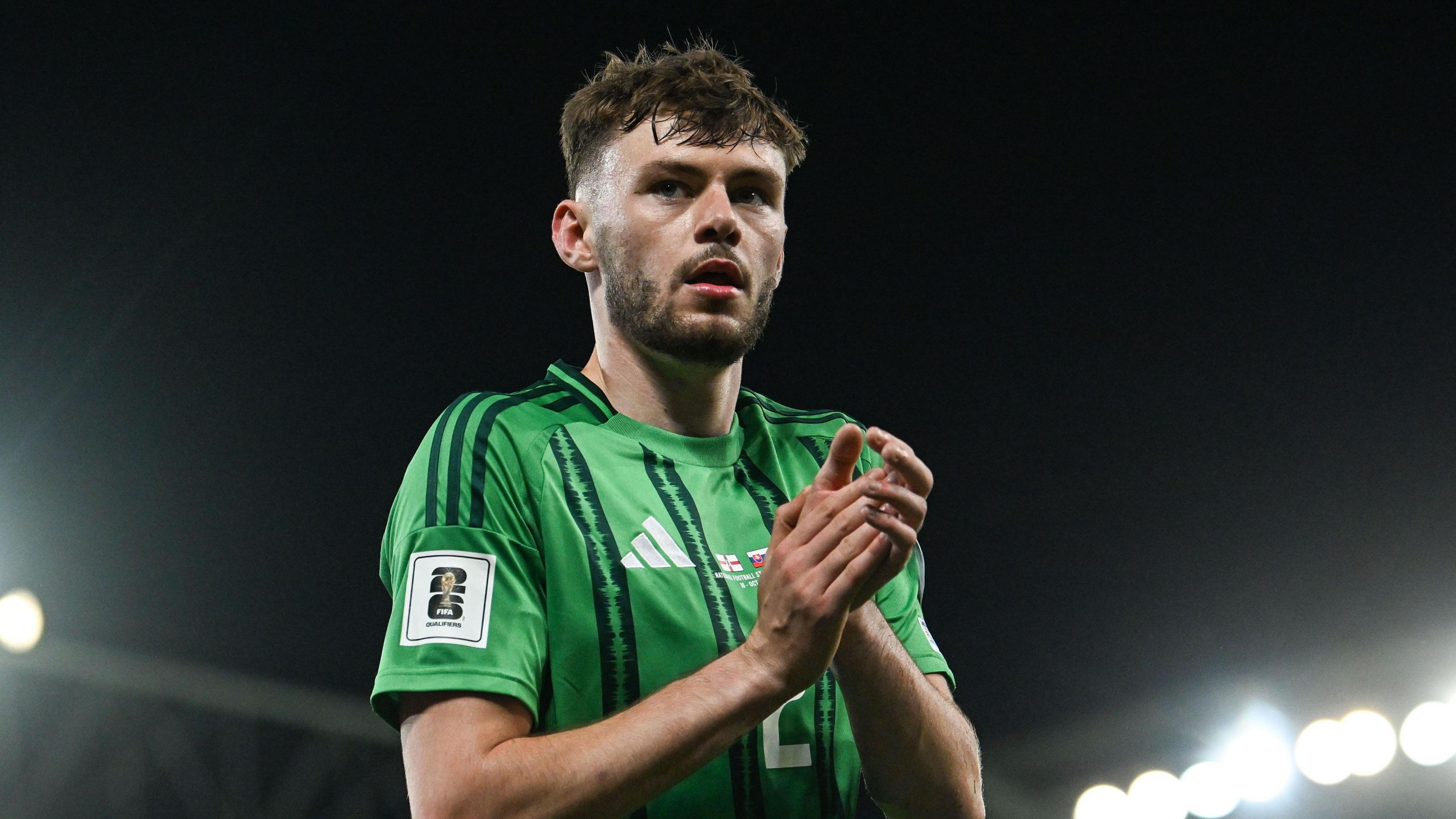 Northern Ireland defender Conor Bradley clasps his hands together